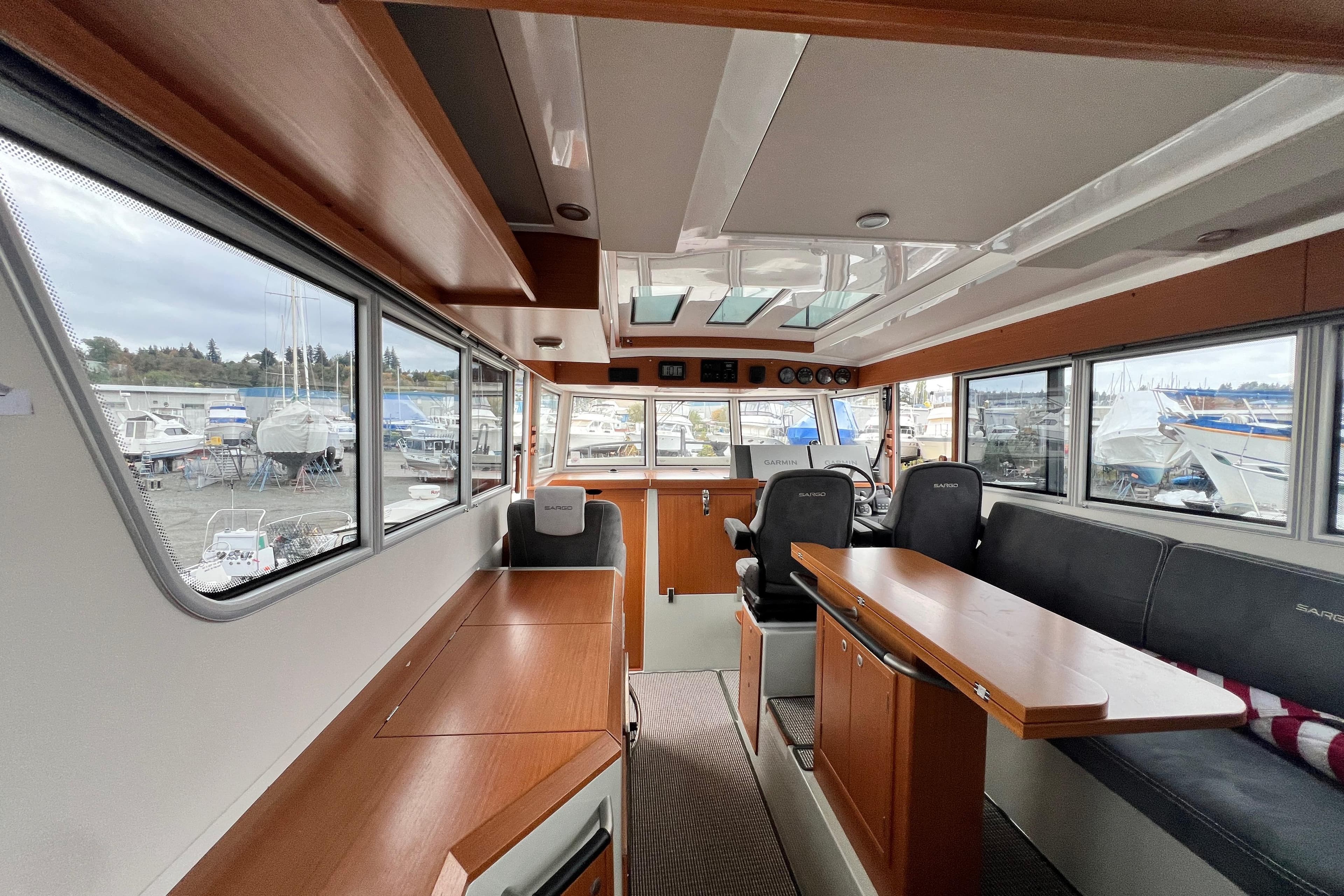 Interior of 2024 Sargo 36 Explorer boat, featuring modern seating and large windows.