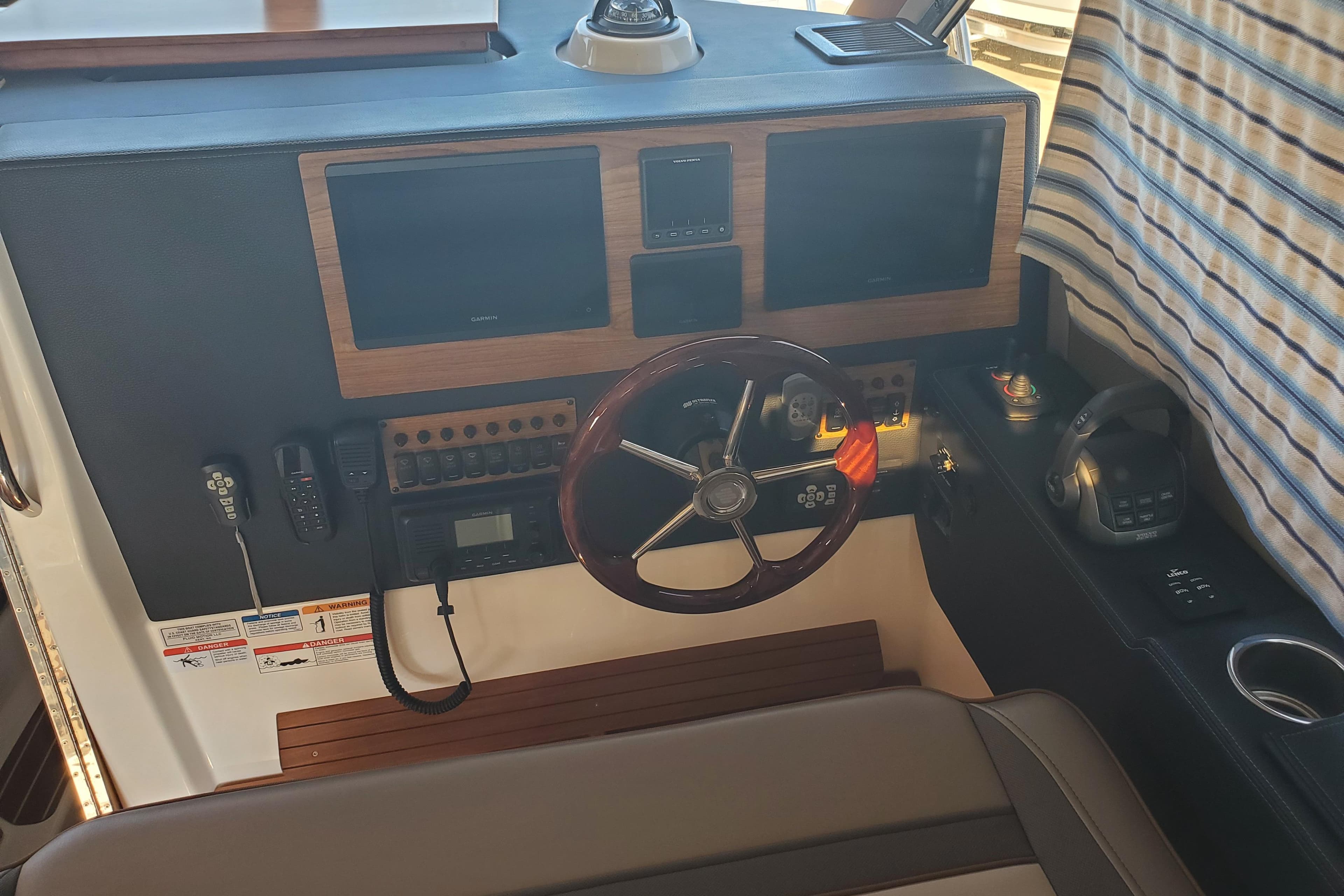 2024 Cutwater C-30 CB helm with dual screens, steering wheel, and control panel.
