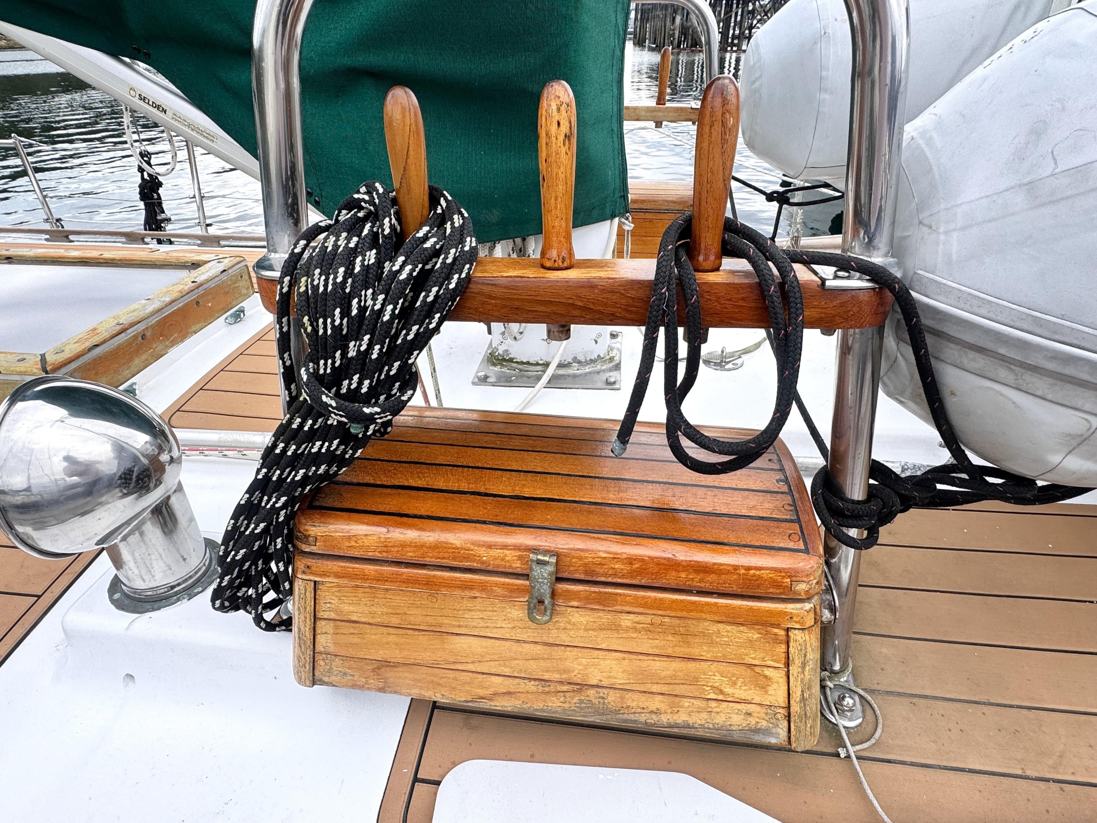 Wooden deck of 1980 Hans Christian 38 MKII sailboat with ropes and storage box.