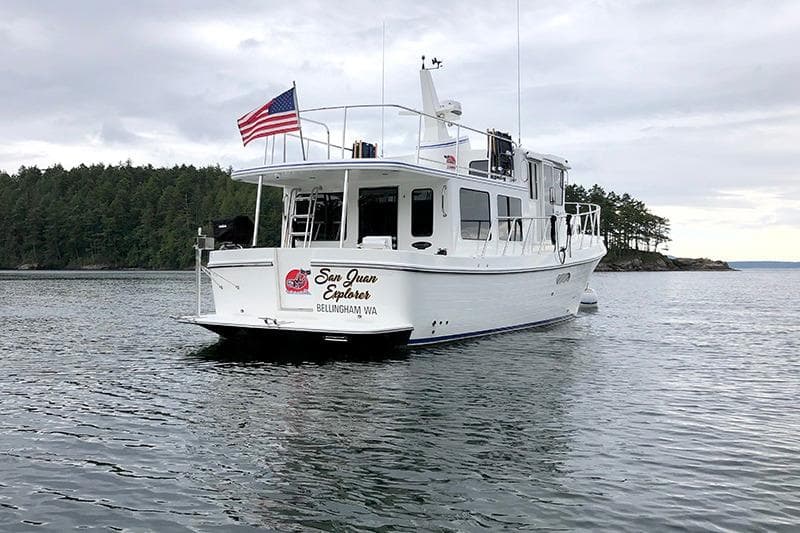 American Tug 362, 2020 model, cruising in scenic waters with forested shoreline.