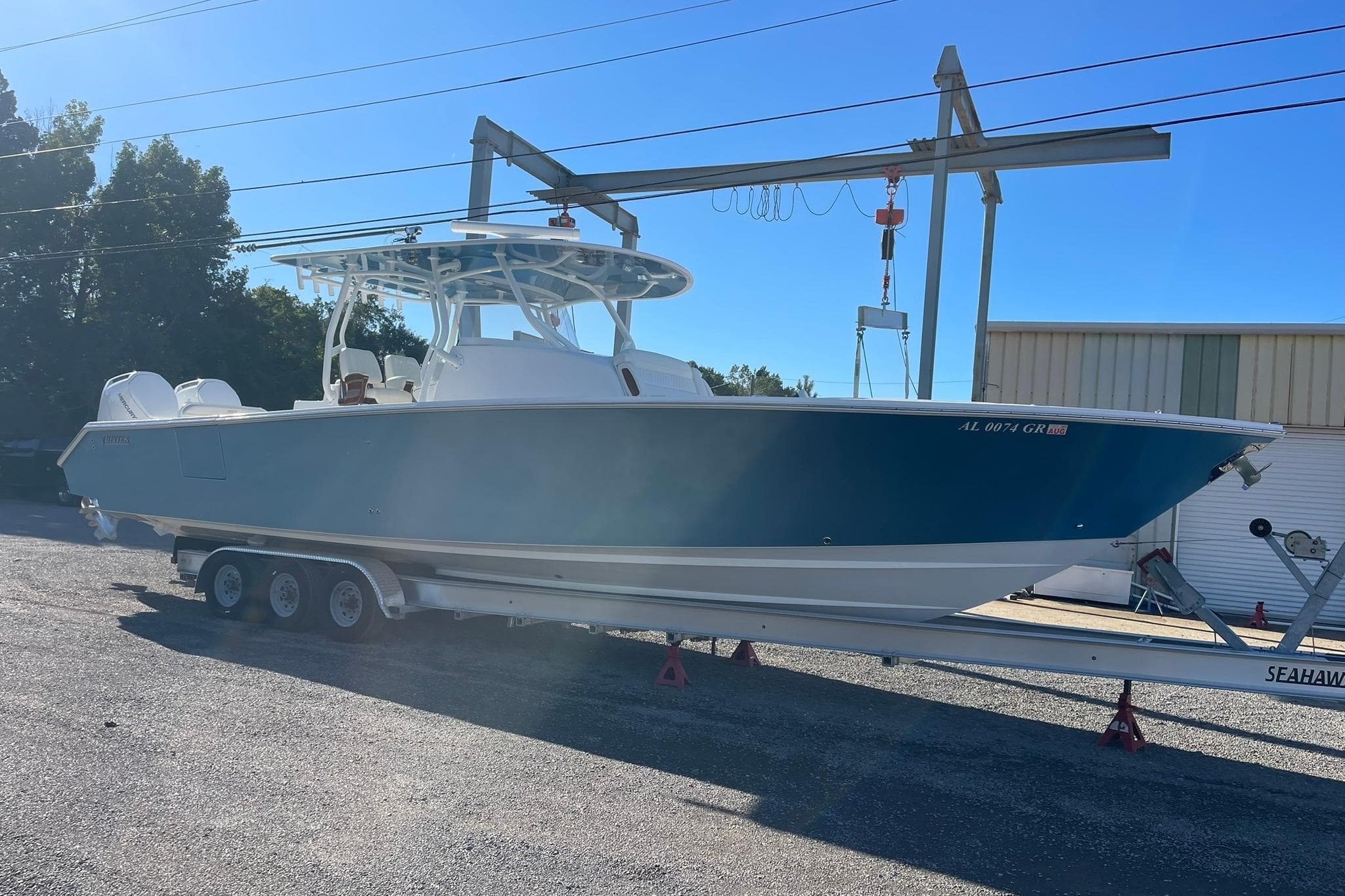 2023 Jupiter 40 boat on trailer in outdoor setting, side view.