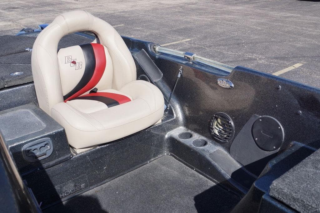 2010 Bass Cat Cougar boat interior with beige and red seat, cup holders, and speaker.