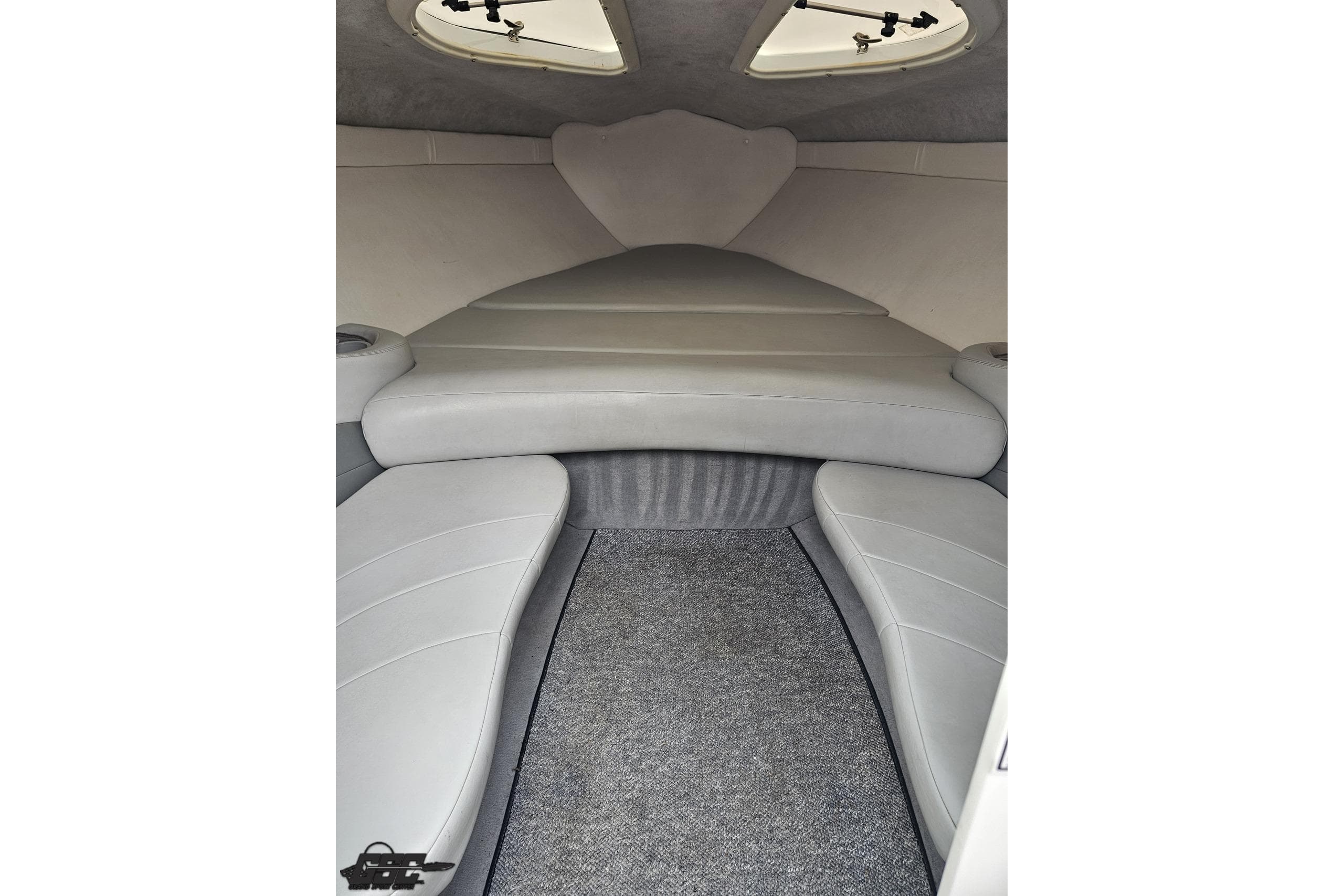 Interior cabin of a 2004 Baja 275 boat with gray seating and carpet.