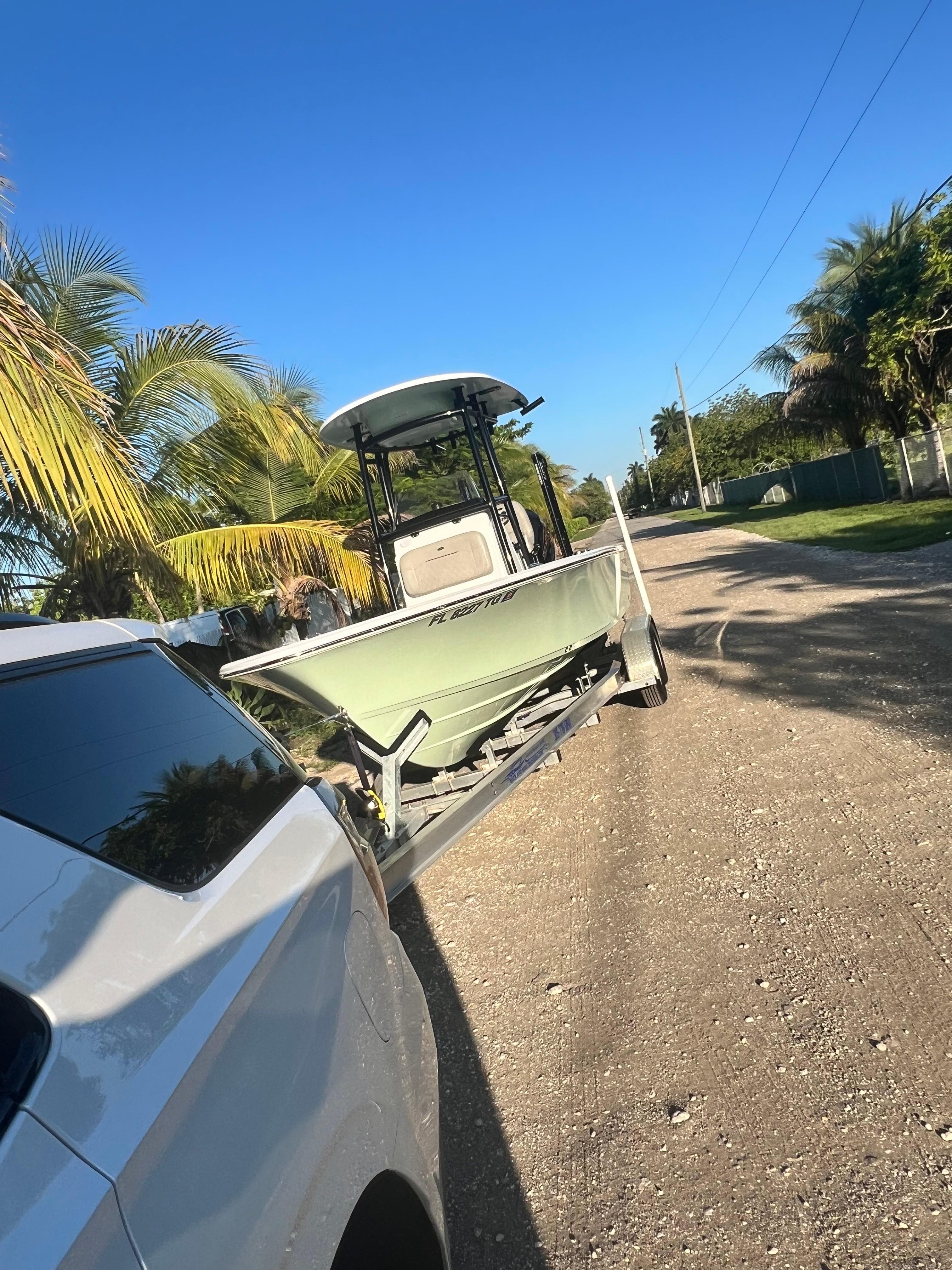 2022 Sportsman Masters 227 Bay Boat on trailer, towed by white vehicle.