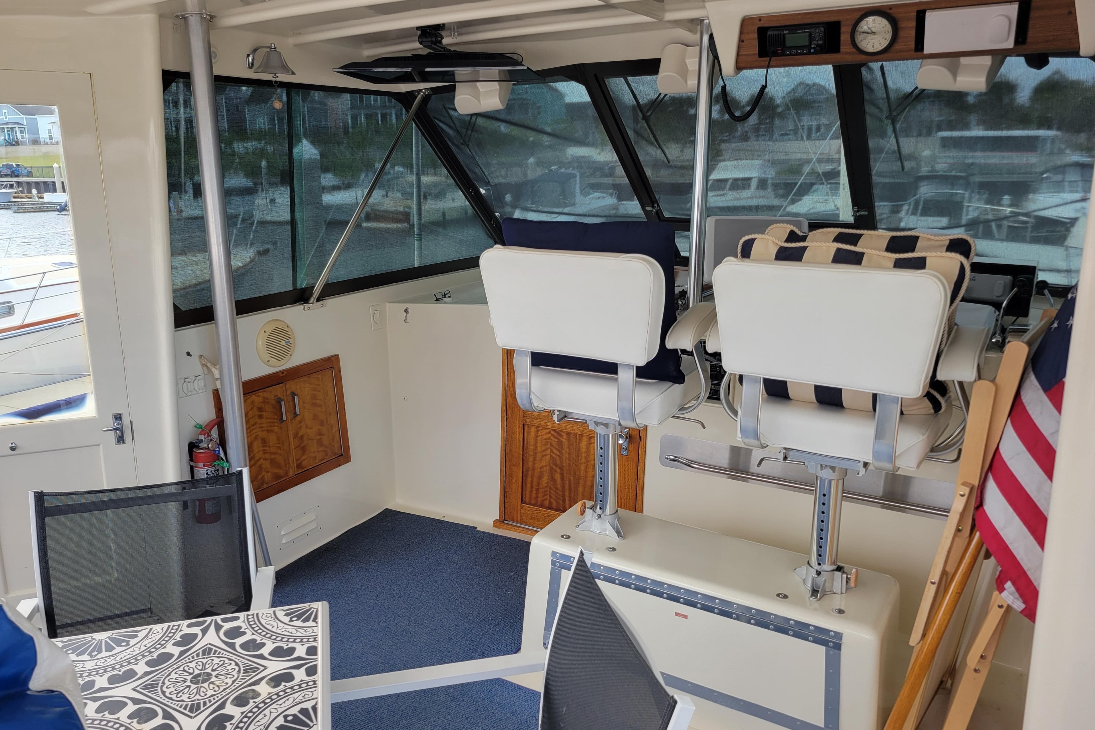 1977 Hatteras 43 Double Cabin interior with helm chairs and nautical decor.