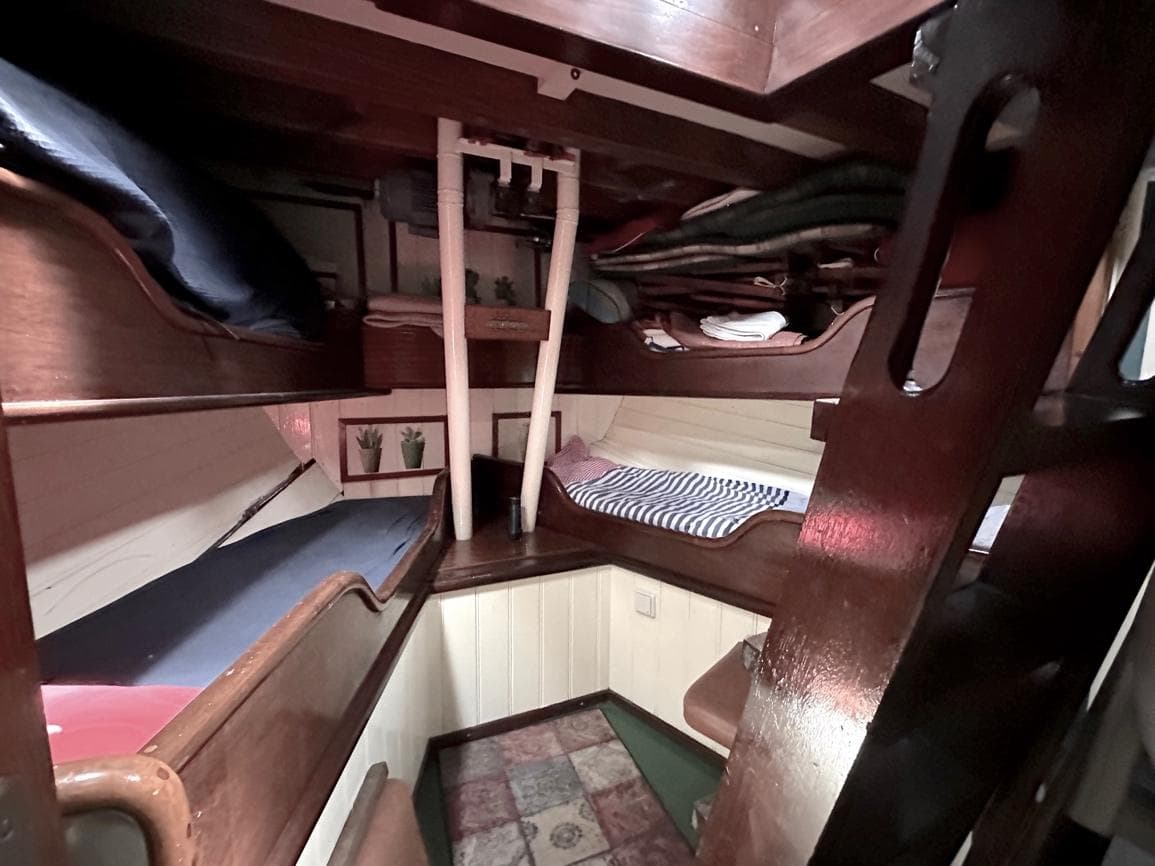 Interior of a 1975 Classic-Yachten Schoner, featuring wooden bunk beds and cozy decor.