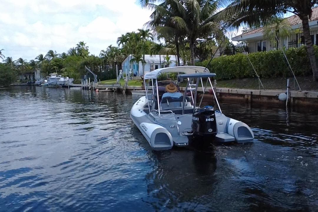 2020 Grand Inflatables G580 boat cruising on a scenic waterway with palm trees.