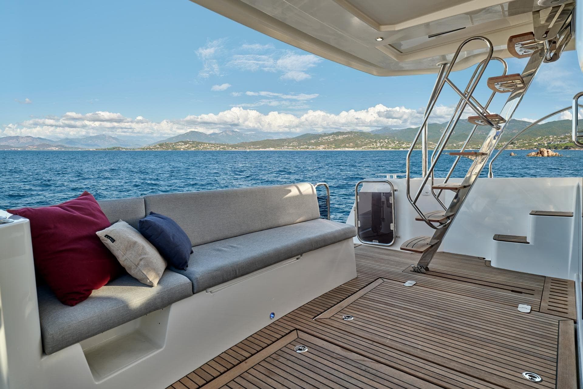 2026 Beneteau Swift Trawler 48 deck with seating, ocean view, and stairs.