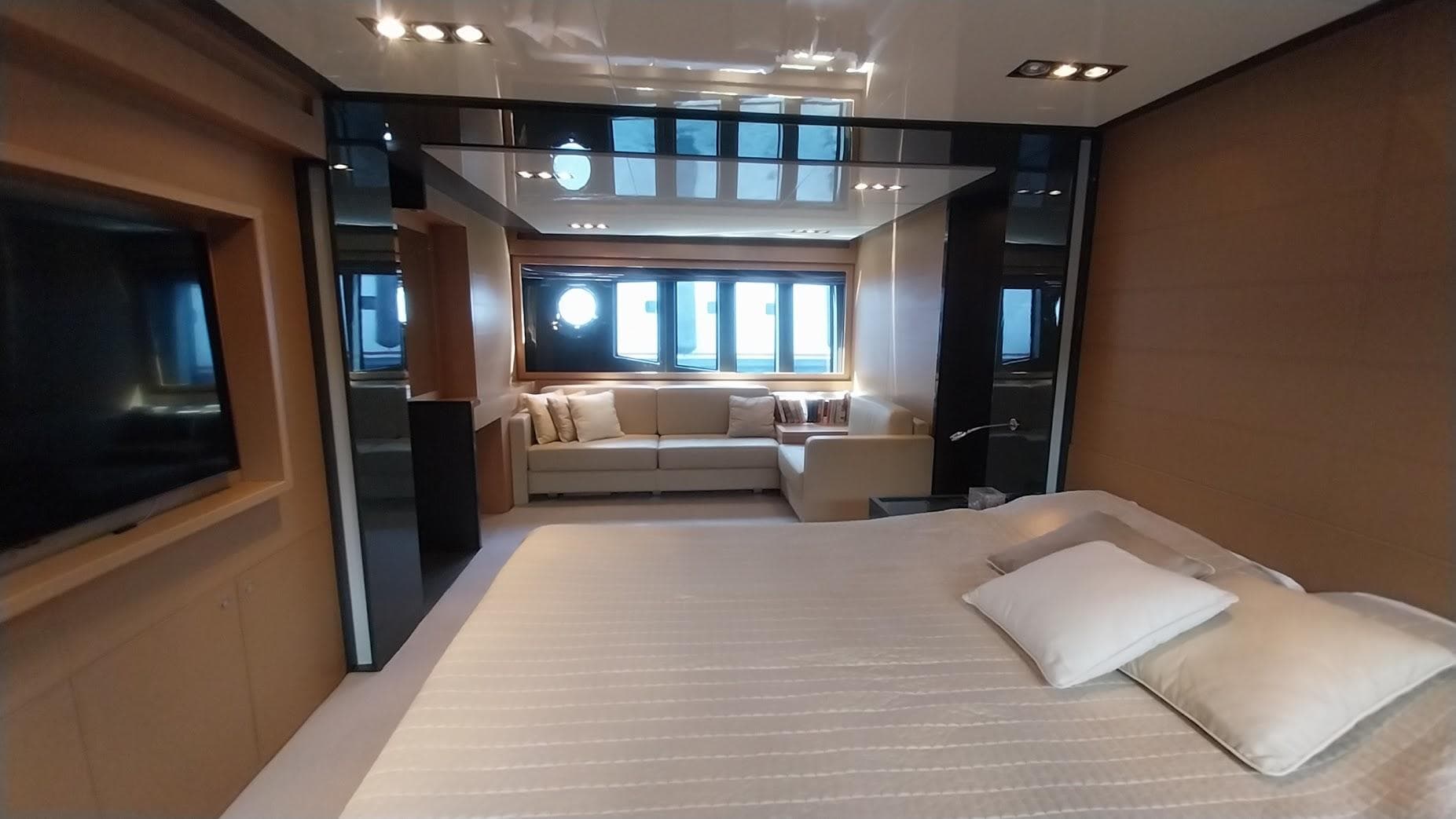 Luxurious bedroom interior of 2010 Riva 86 Domino yacht with modern design and cozy seating area.
