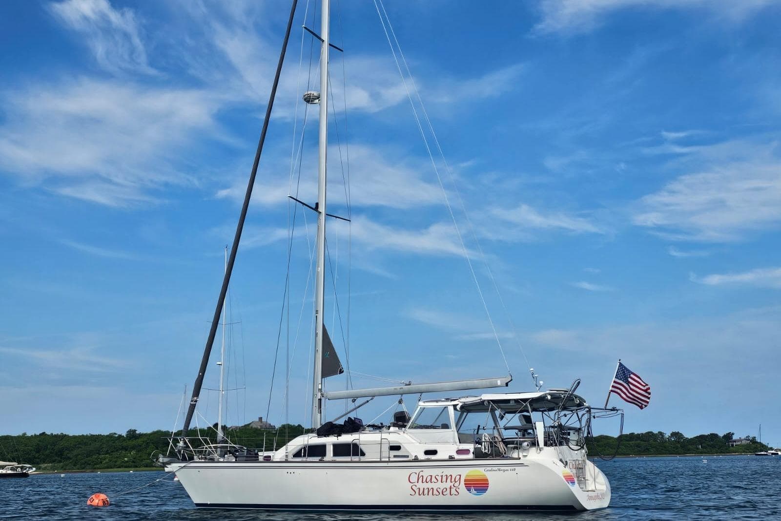 Sailboat "Chasing Sunsets," Catalina Morgan 440, 2005, on calm water with American flag.