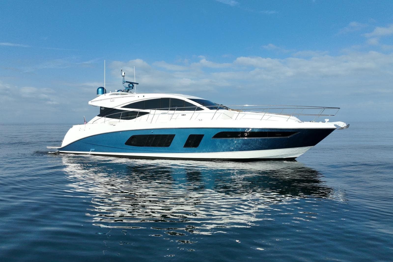 2016 Sea Ray L650 yacht cruising on calm ocean waters under a clear blue sky.