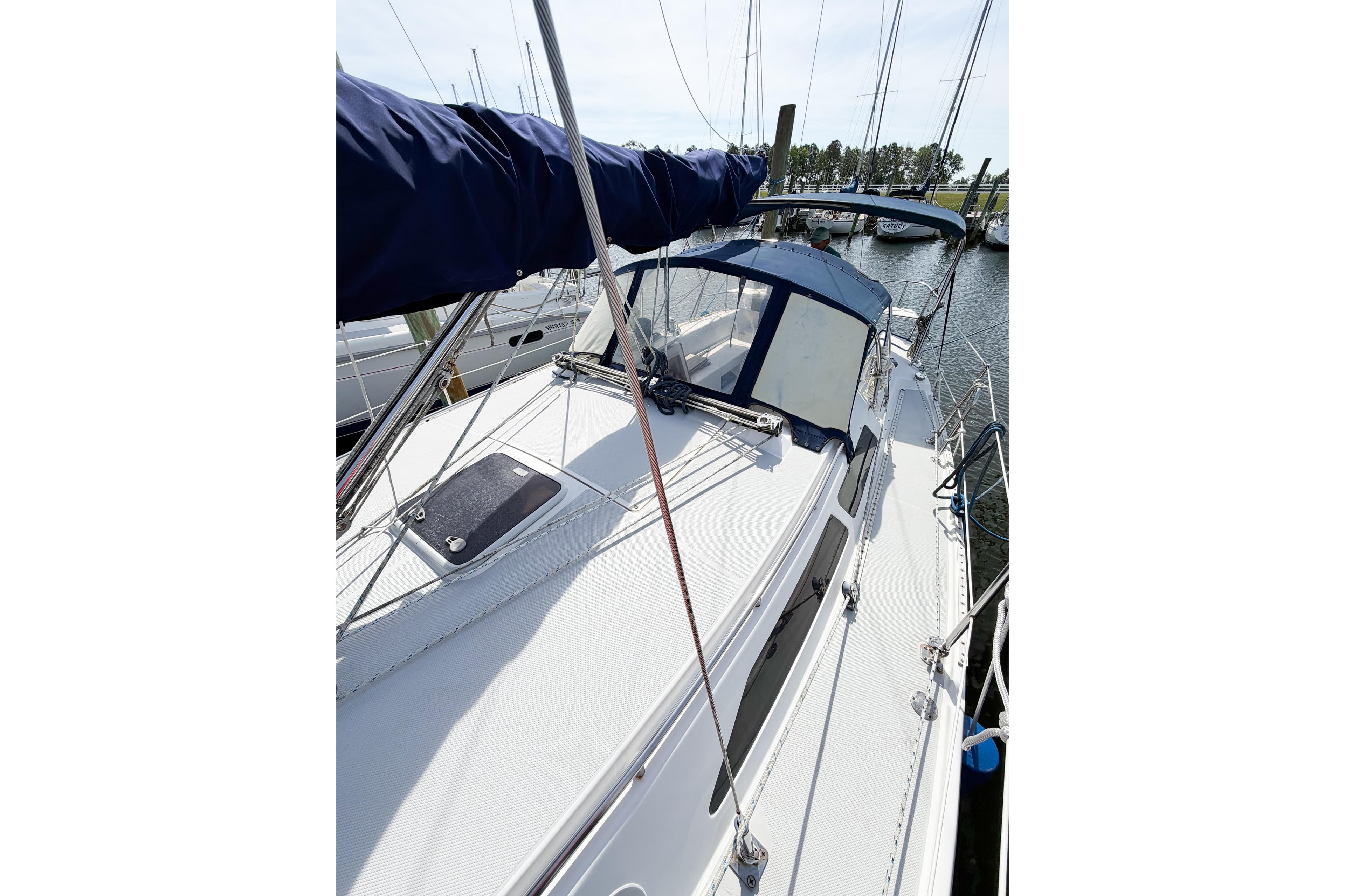 2003 Catalina 34 MkII sailboat docked, featuring a sleek deck and blue canopy.