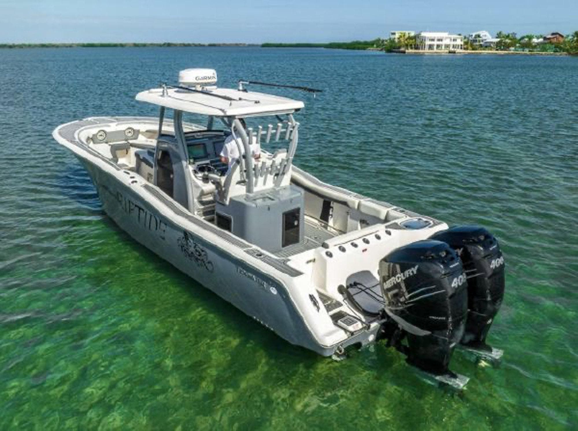 2020 Tidewater 320 CC Adventure boat with dual Mercury engines on clear water.