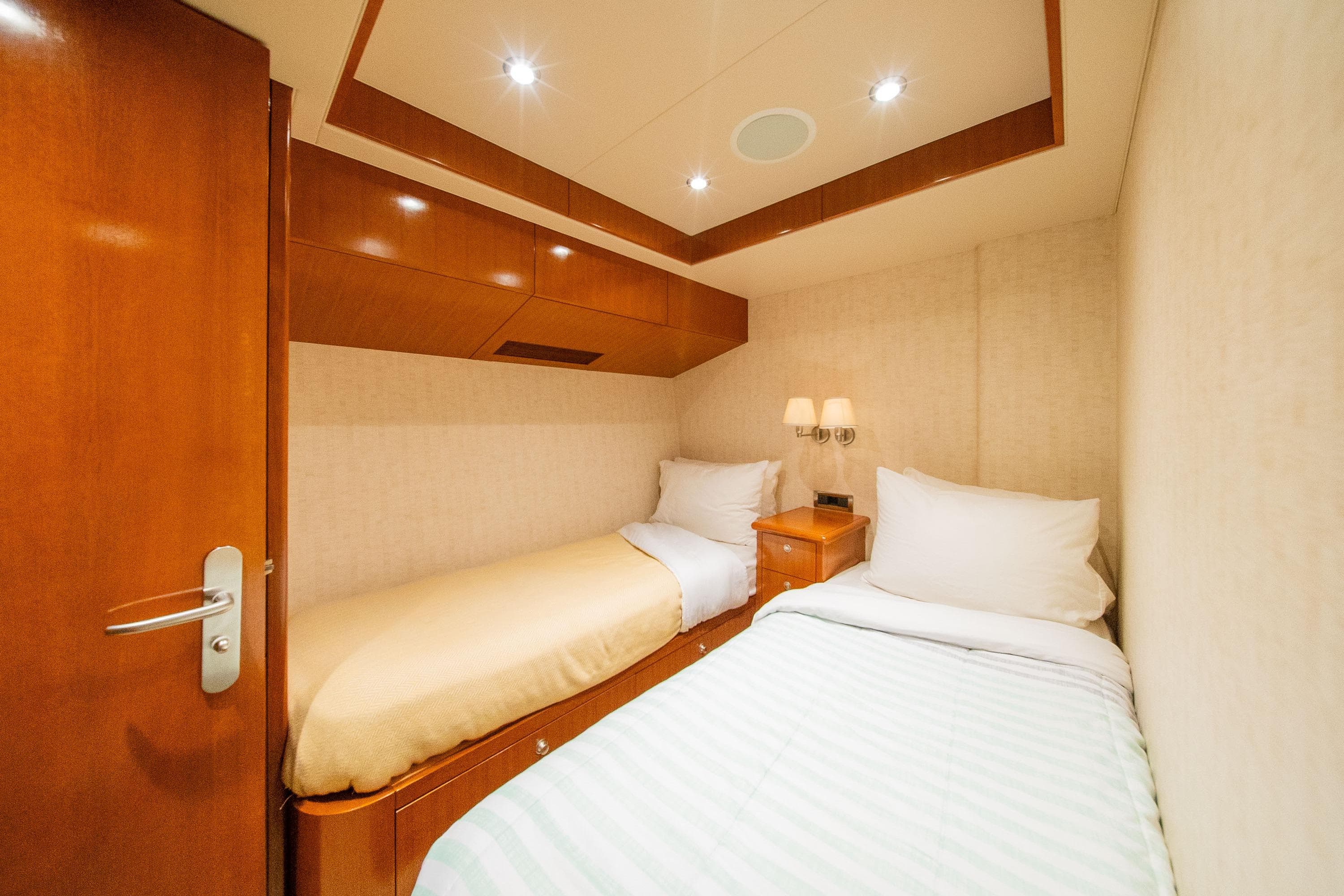 Luxurious twin cabin in 2002 Striker 76 Sportfish Motor Yacht, featuring elegant wood finishes.