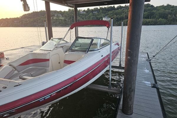 2008 Bryant 233 boat docked on a lake at sunset.