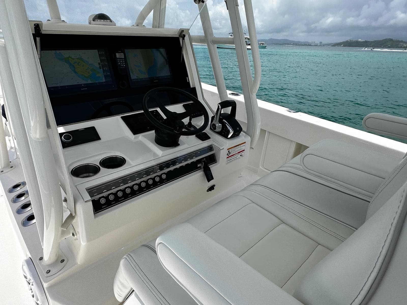 2024 SeaVee 340Z boat cockpit with modern controls and dual screens on a calm sea.