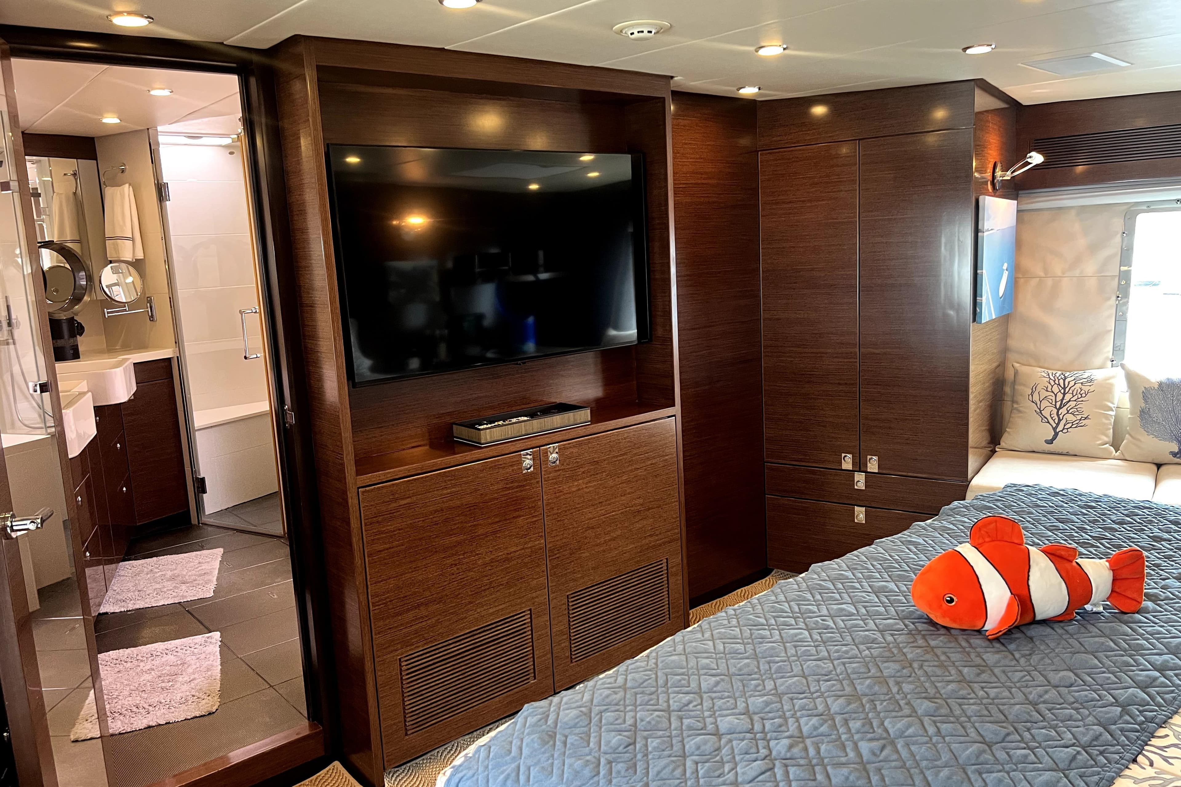 Luxurious Nordhavn N78 yacht bedroom with TV, ensuite bathroom, and plush decor.