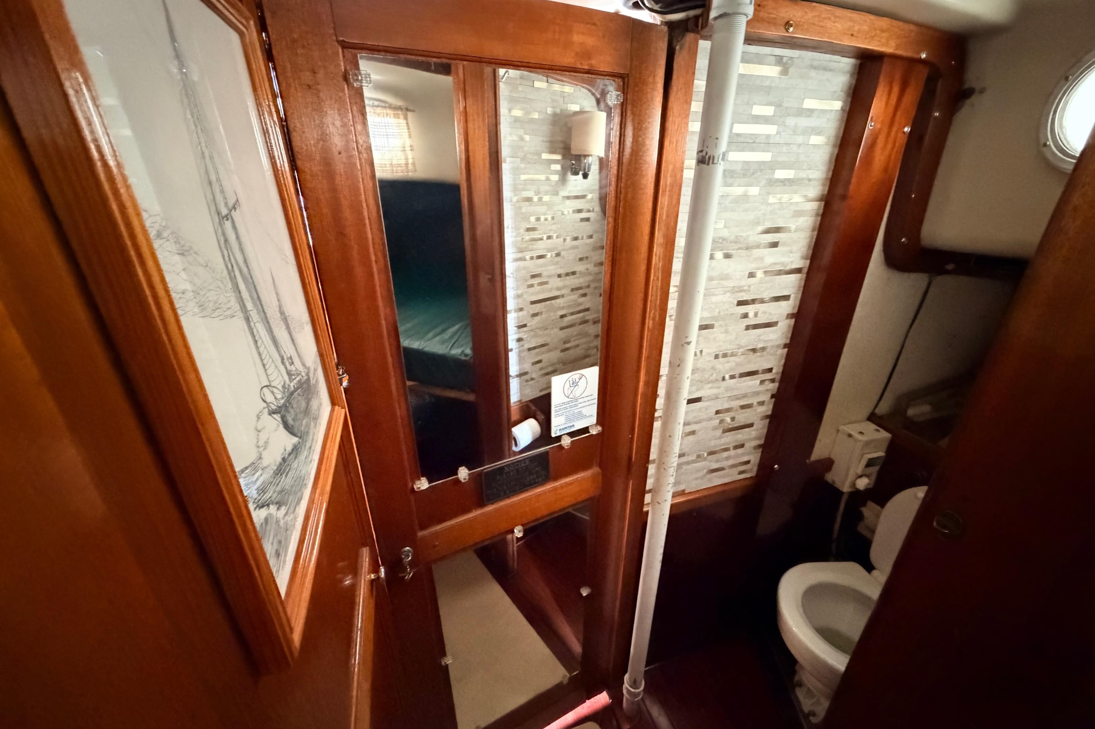 Interior of a 1964 Columbia 33 sailboat featuring a compact bathroom with wooden accents.