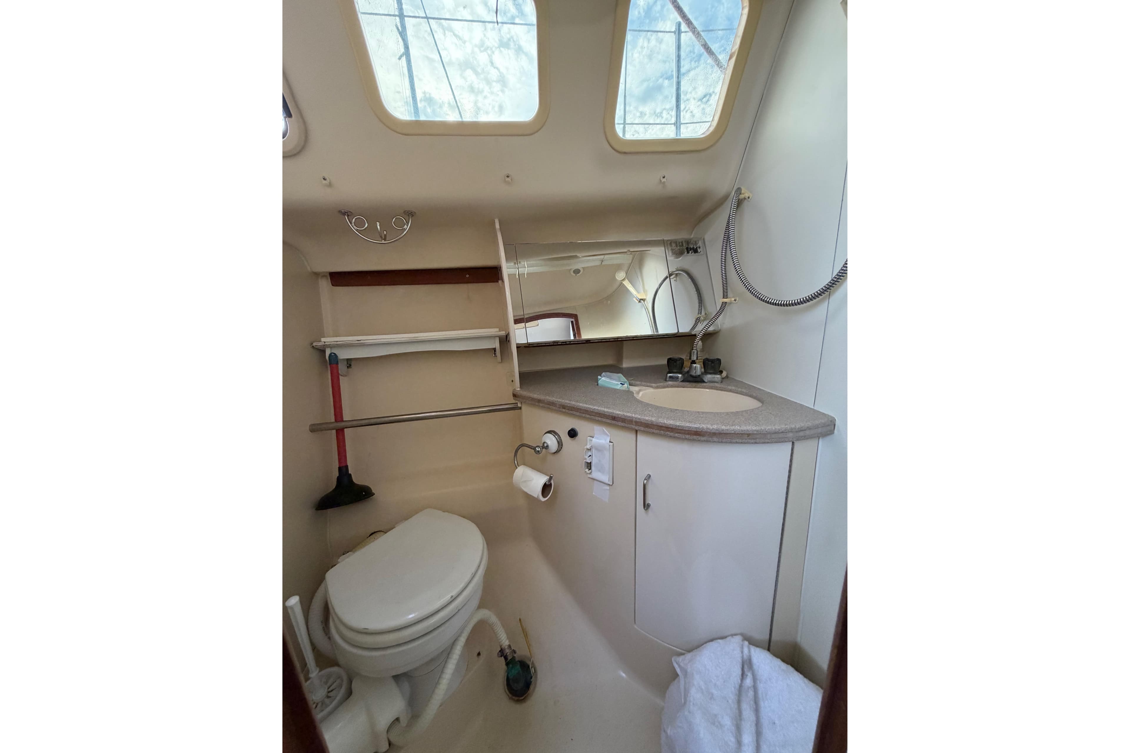 Compact bathroom in a 2000 Hunter 310 sailboat with skylight and modern amenities.