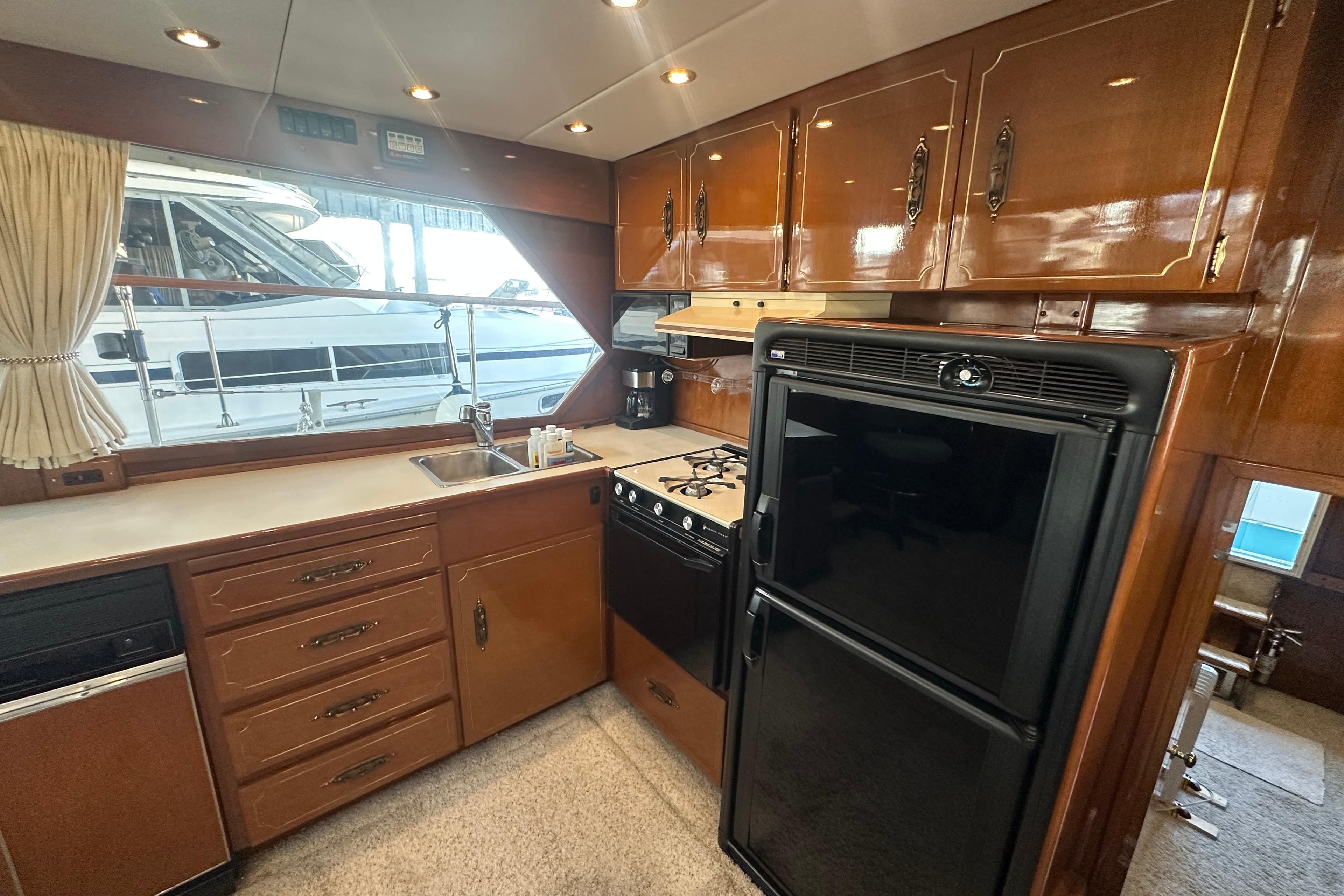 1972 Tollycraft 42 Tri-Cabin yacht kitchen with wood cabinets and modern appliances.