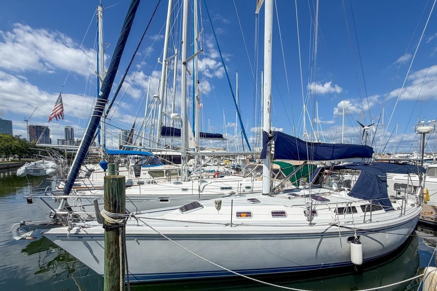 Sailboat Catalina 42, 1993 model, docked in a marina under a clear blue sky.