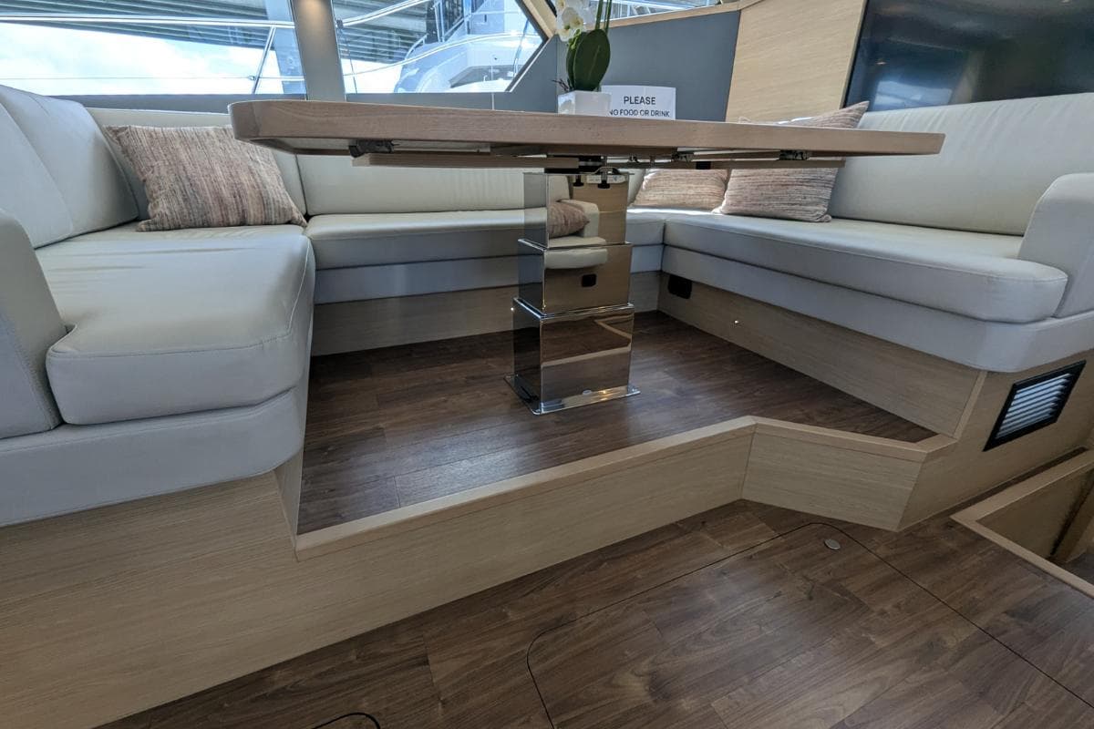 Luxurious interior of 2026 Aquila 50 Yacht with elegant seating and wooden flooring.