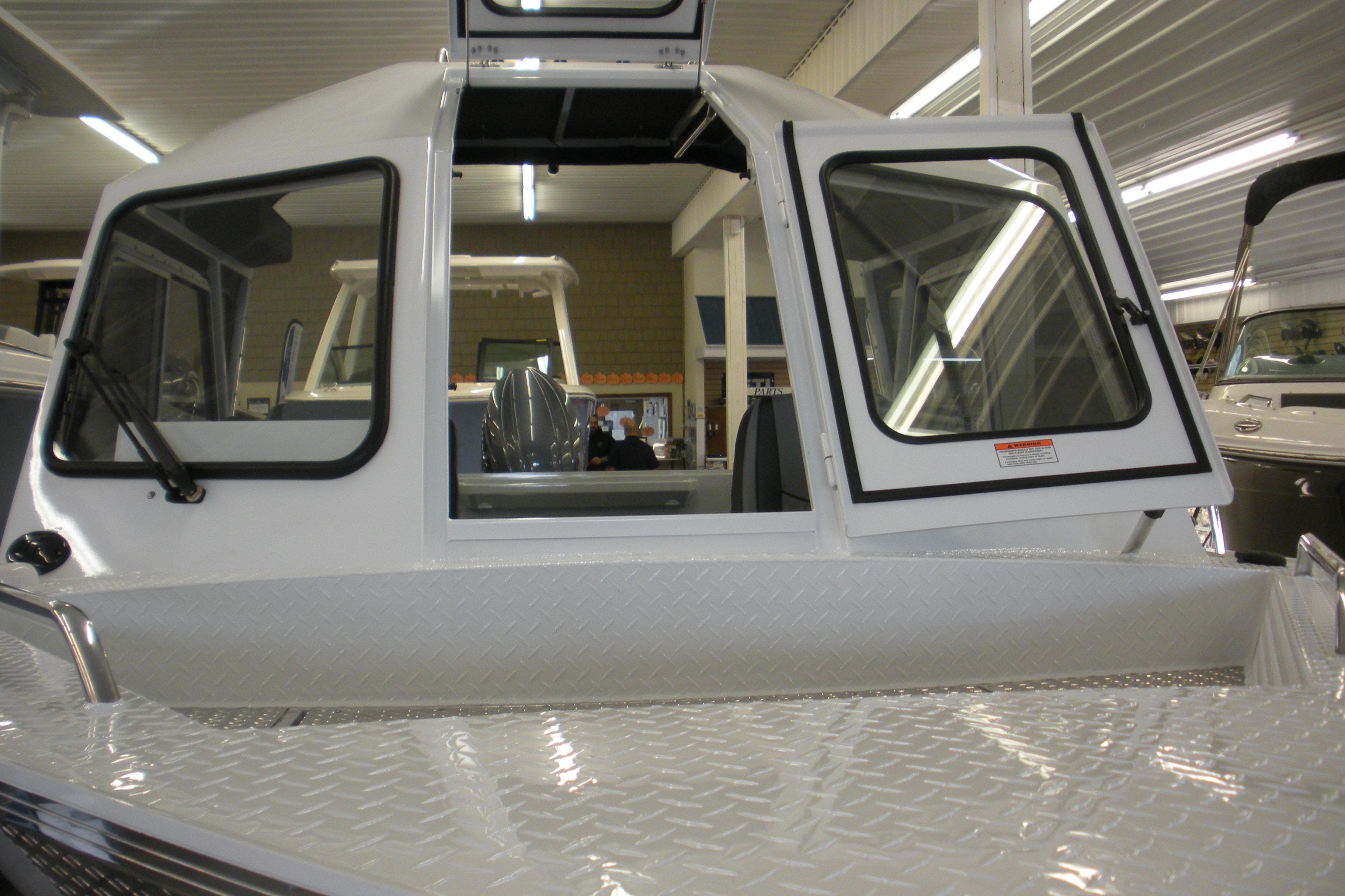 2026 Duckworth 21 Discovery boat with open cabin windows in a showroom.