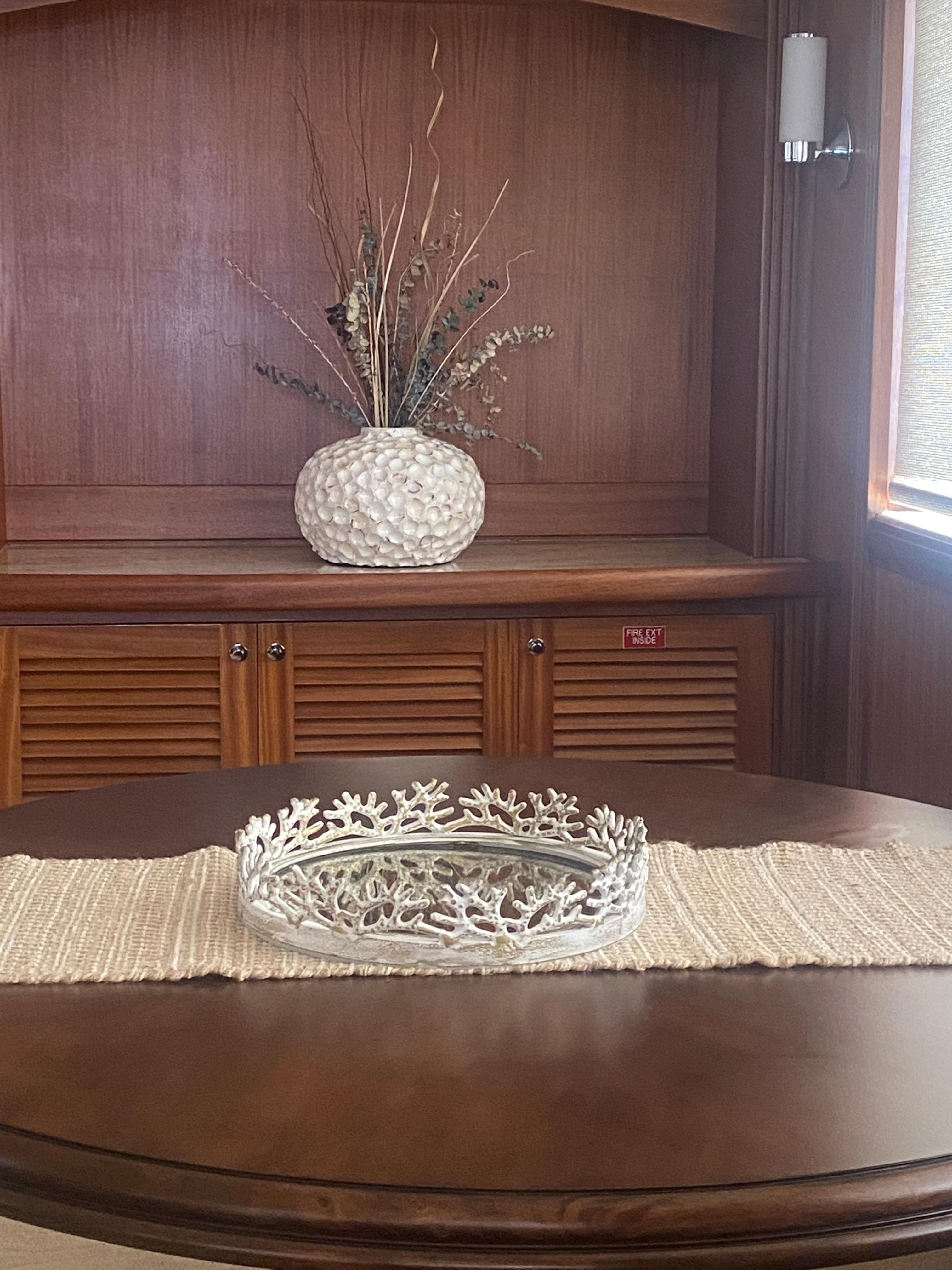 Elegant wooden interior with decorative vase and coral centerpiece on Allseas Expedition yacht, 2018.