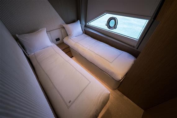Twin beds in a luxurious 2023 Ferretti Yachts 720 cabin with ocean view.
