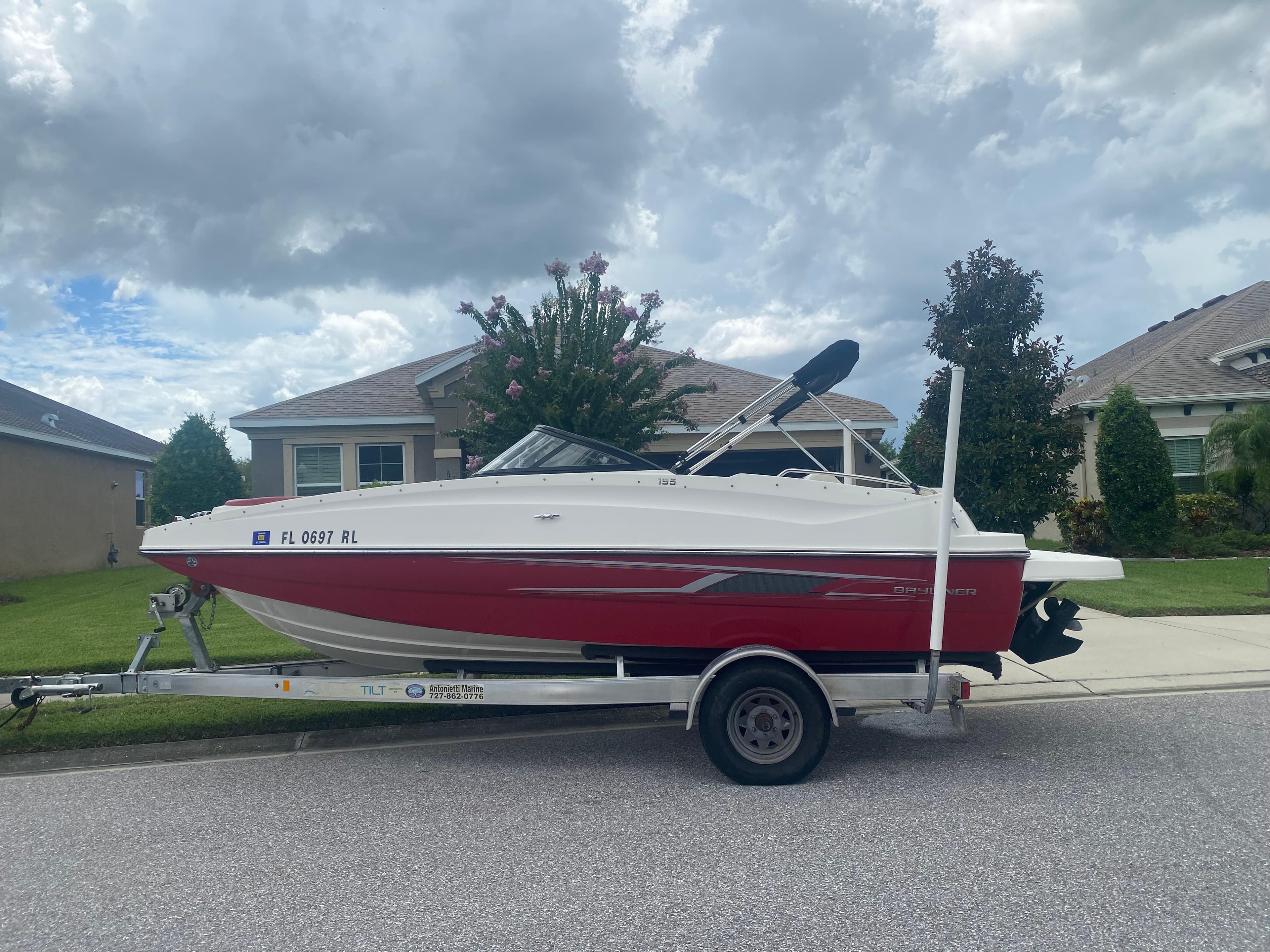 2016 Bayliner 195 Deck Boat on a trailer in a residential neighborhood.