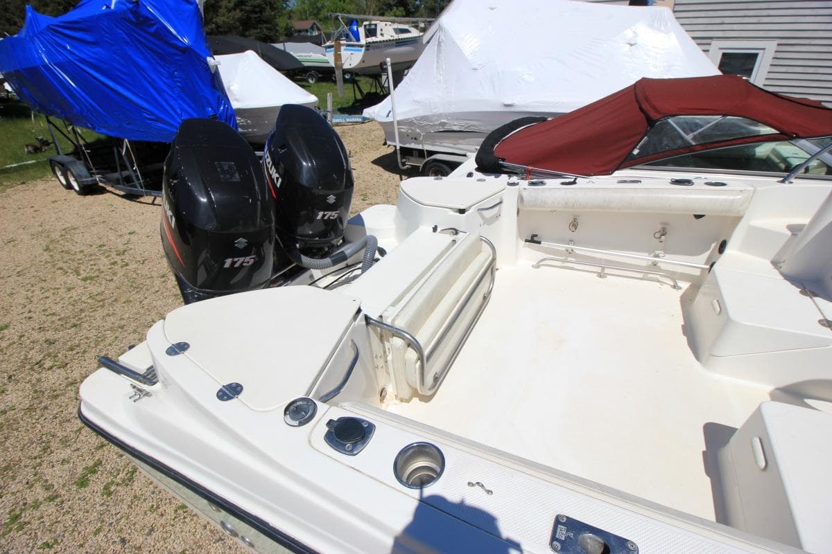 2008 Trophy 2302 Walkaround boat with dual Suzuki 175 engines, parked outdoors.