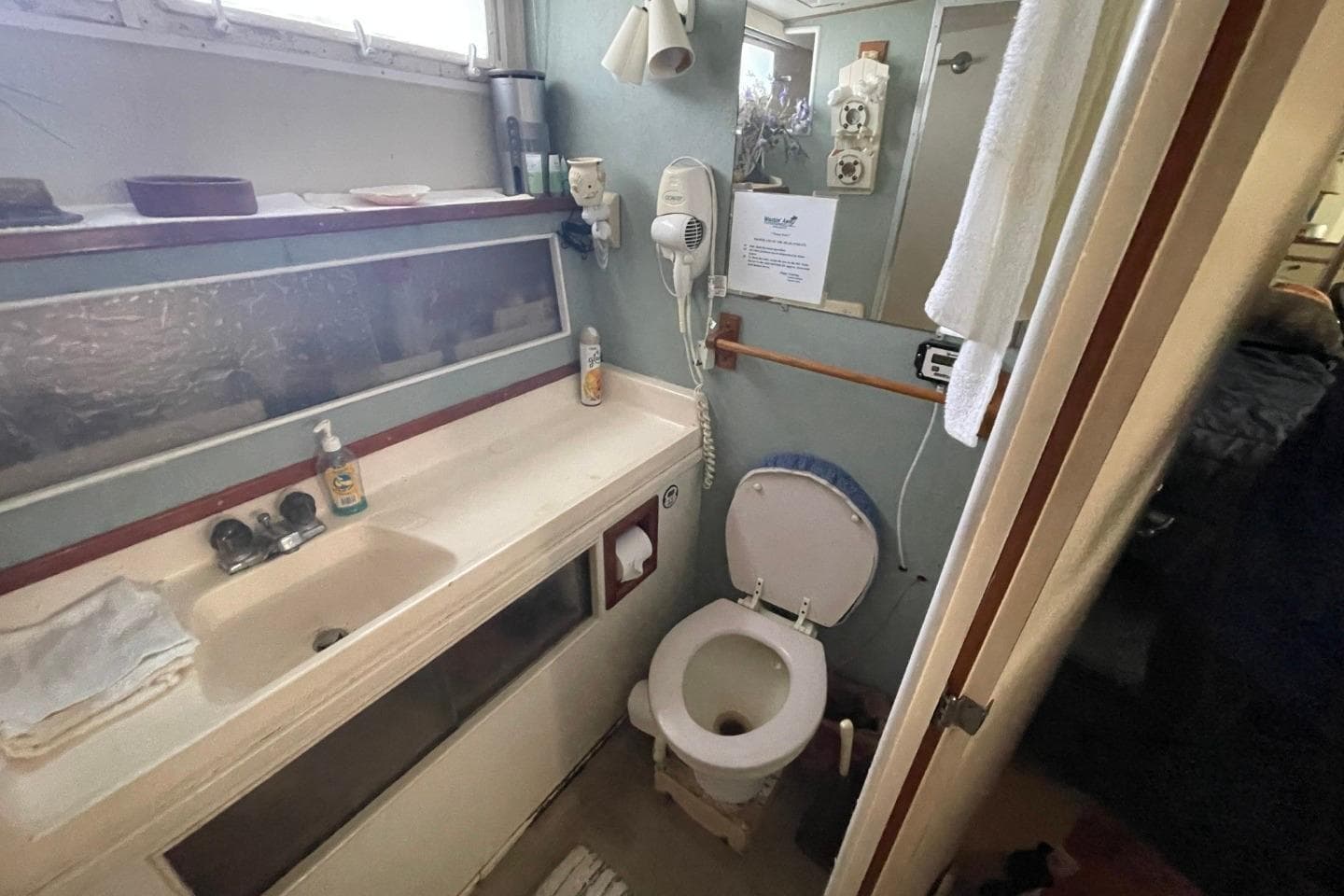 Bathroom interior of 1969 Chris-Craft 47 Commander yacht, featuring sink and toilet.