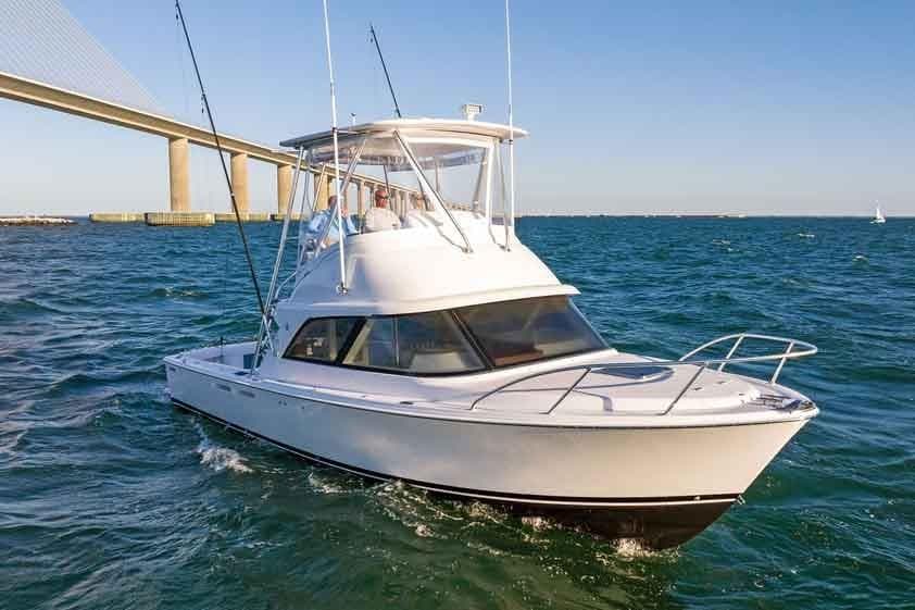 Manufacturer Provided Image: 2026 Bertram 35 Flybridge yacht cruising under a bridge on open water.
