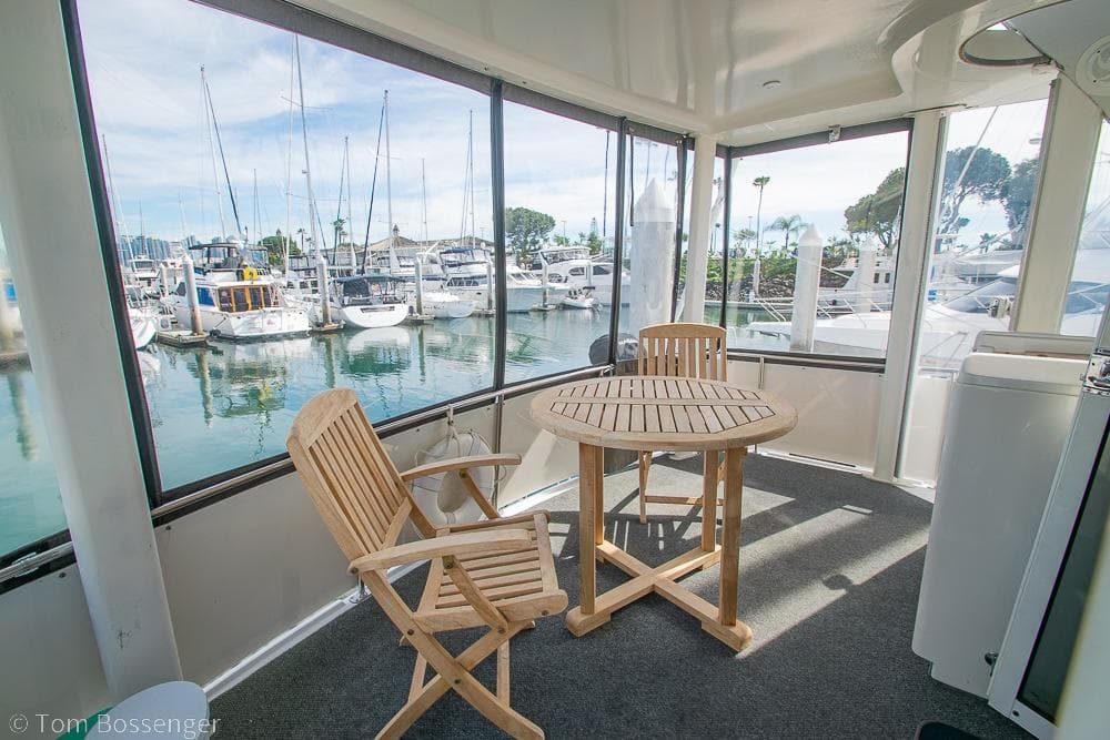 1996 Carver 370 Aft Cabin Motor Yacht interior with wooden chairs and marina view.