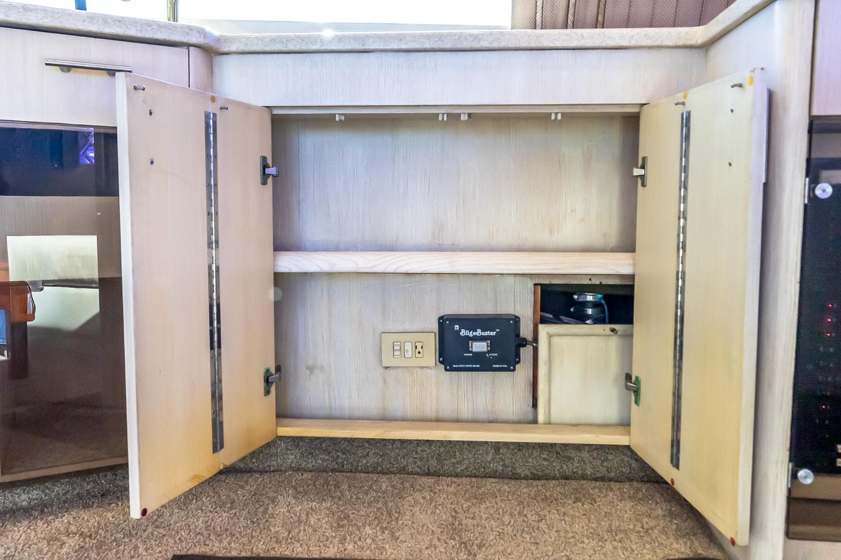 Open cabinet on 1998 Ocean Yachts 48 Super Sport, featuring BilgeBuster system.