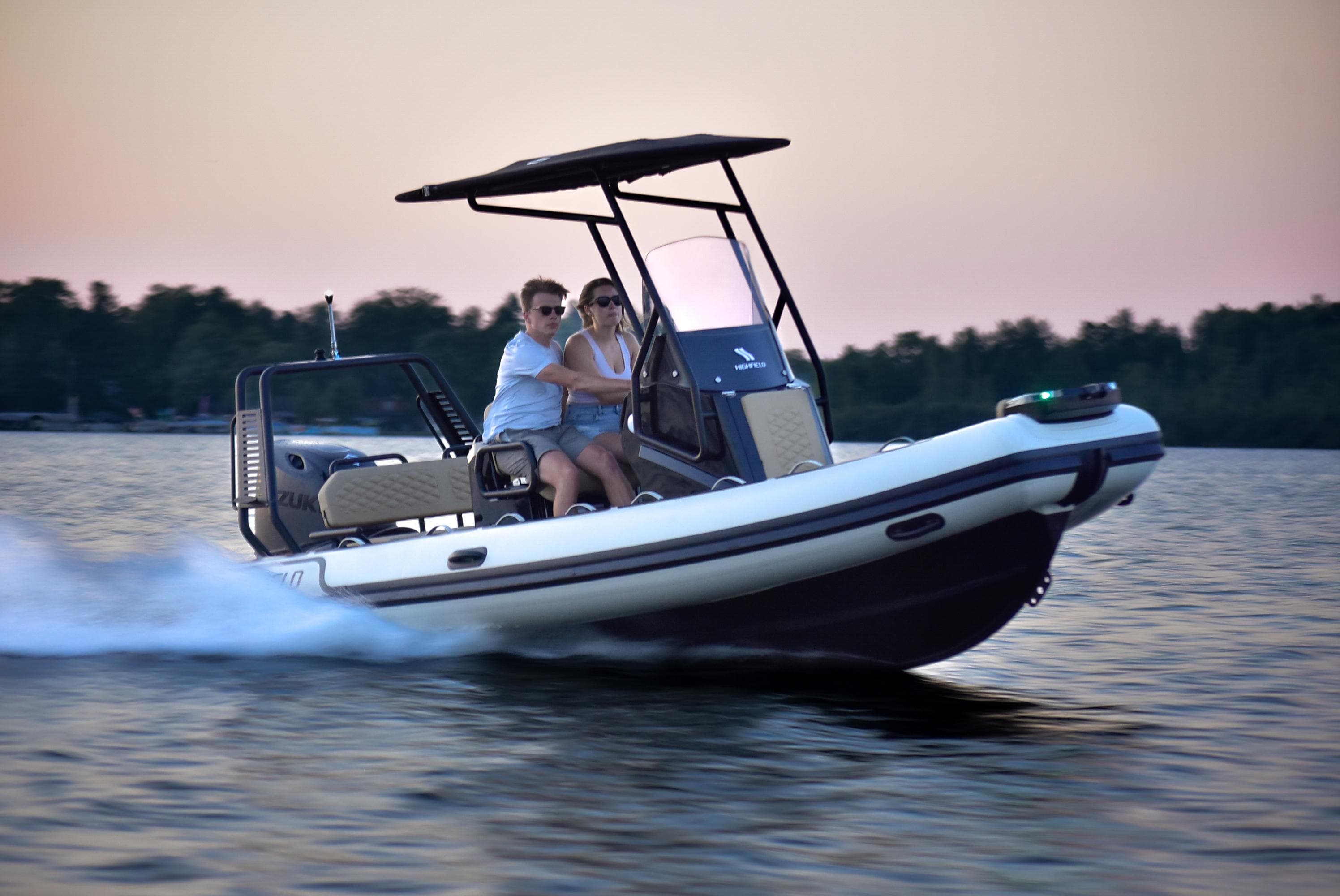 2025 Highfield Sport 560 boat cruising on a lake at sunset.