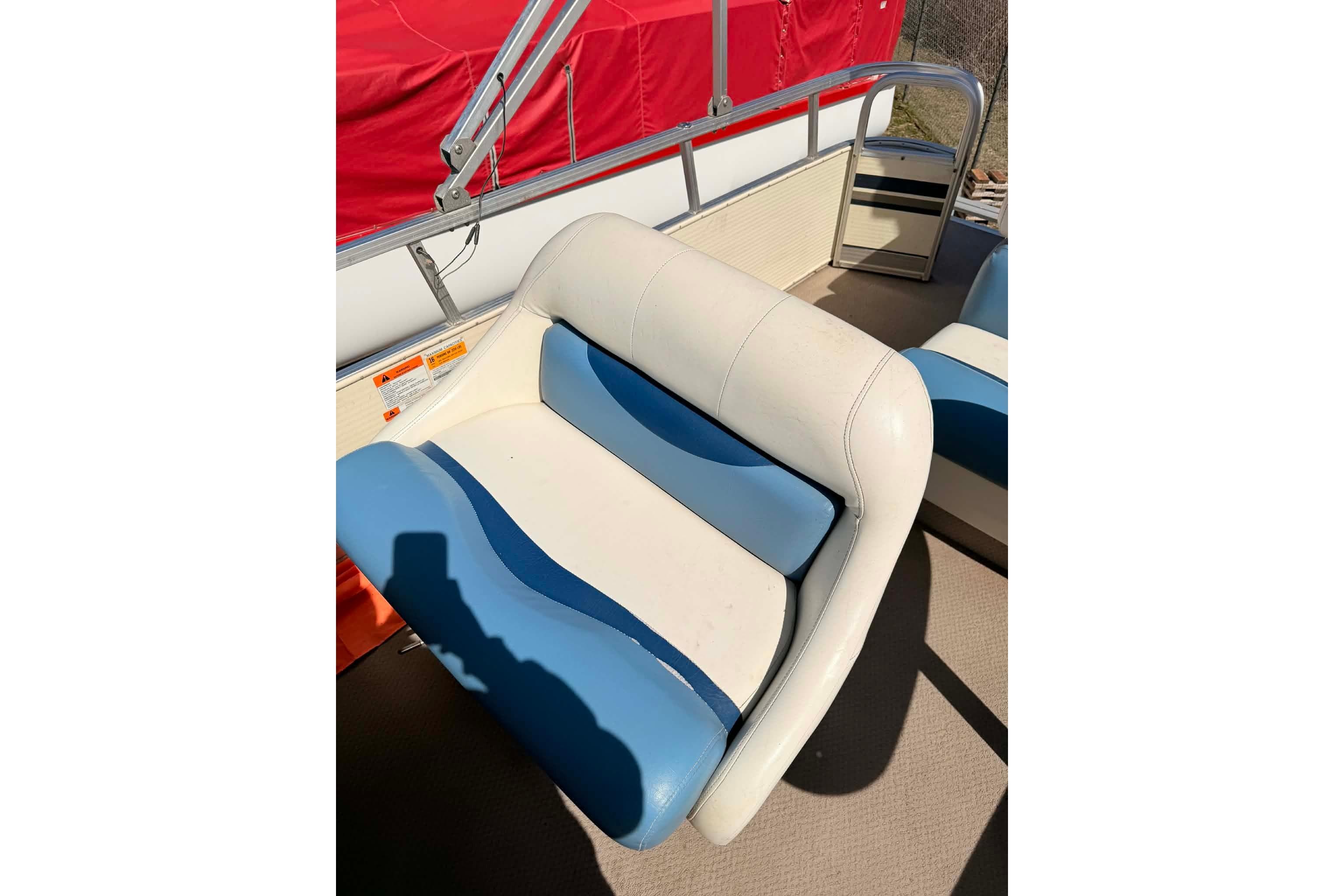 2004 Lowe Jamaica 250 boat seat with blue and white upholstery, red cover in background.