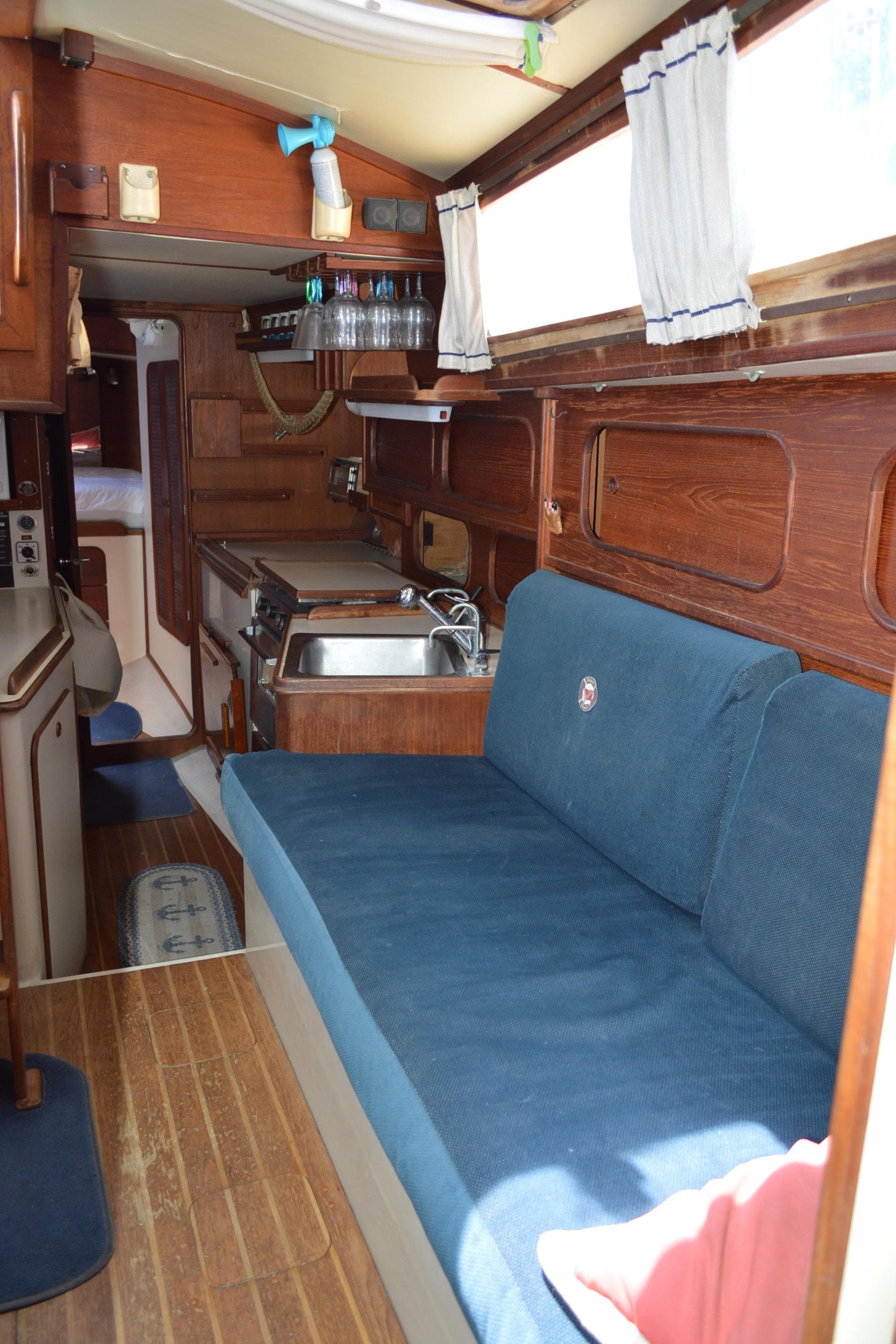 Interior of 1984 Irwin 38 sailboat with blue seating and wooden finishes.