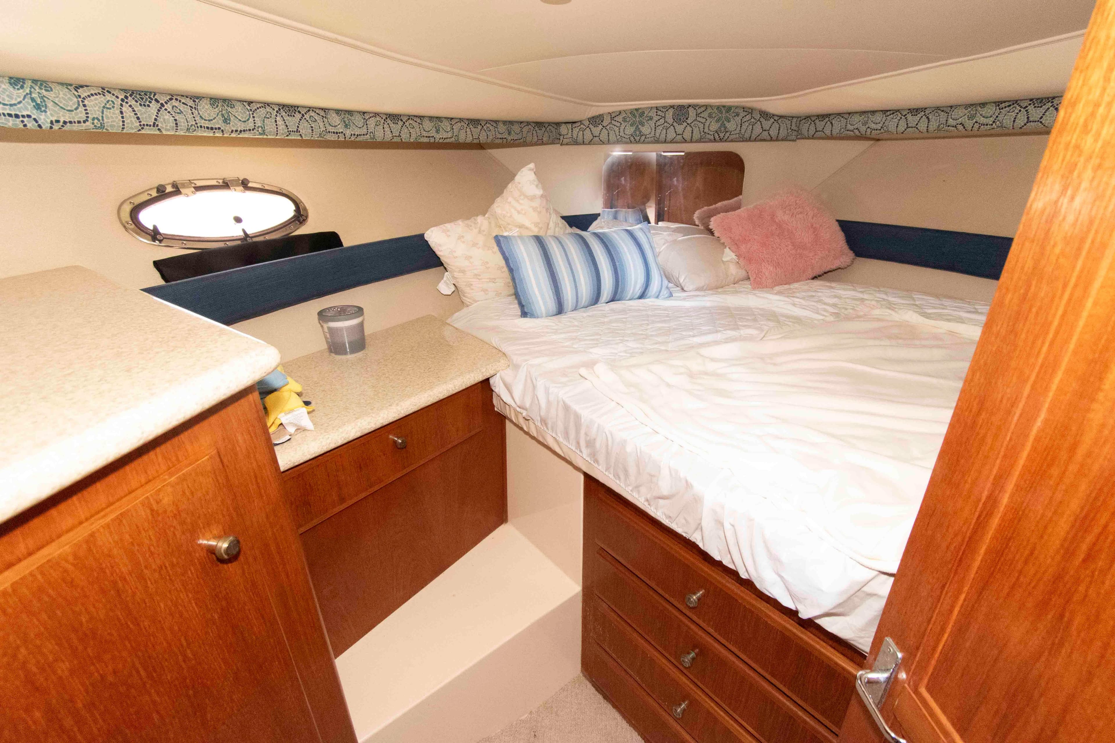 Cozy cabin interior of 2000 Carver 356 Aft Cabin Motor Yacht with bed and storage.