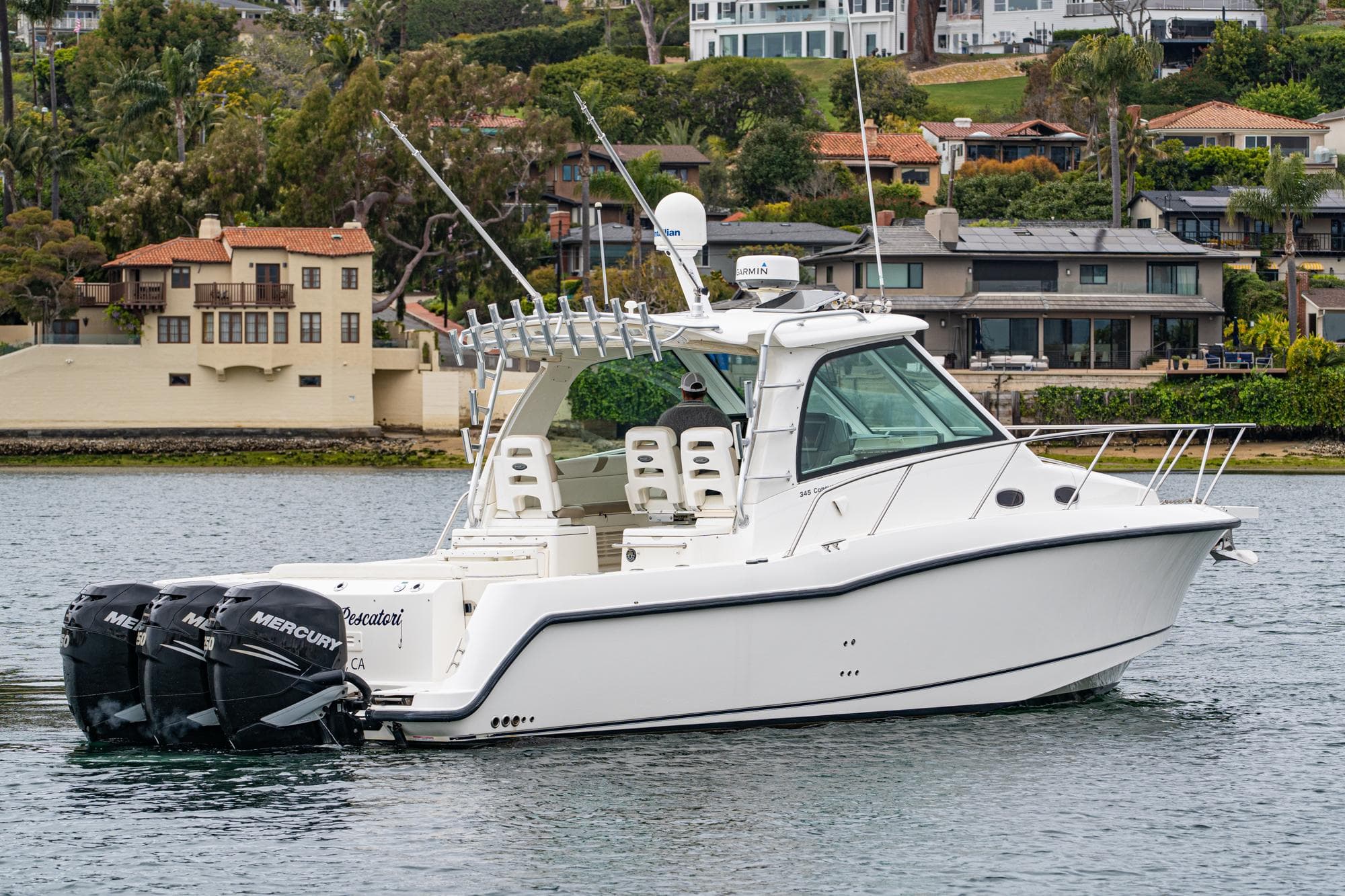 2009 Boston Whaler 345 Conquest boat on water, with twin Mercury engines, near waterfront homes.