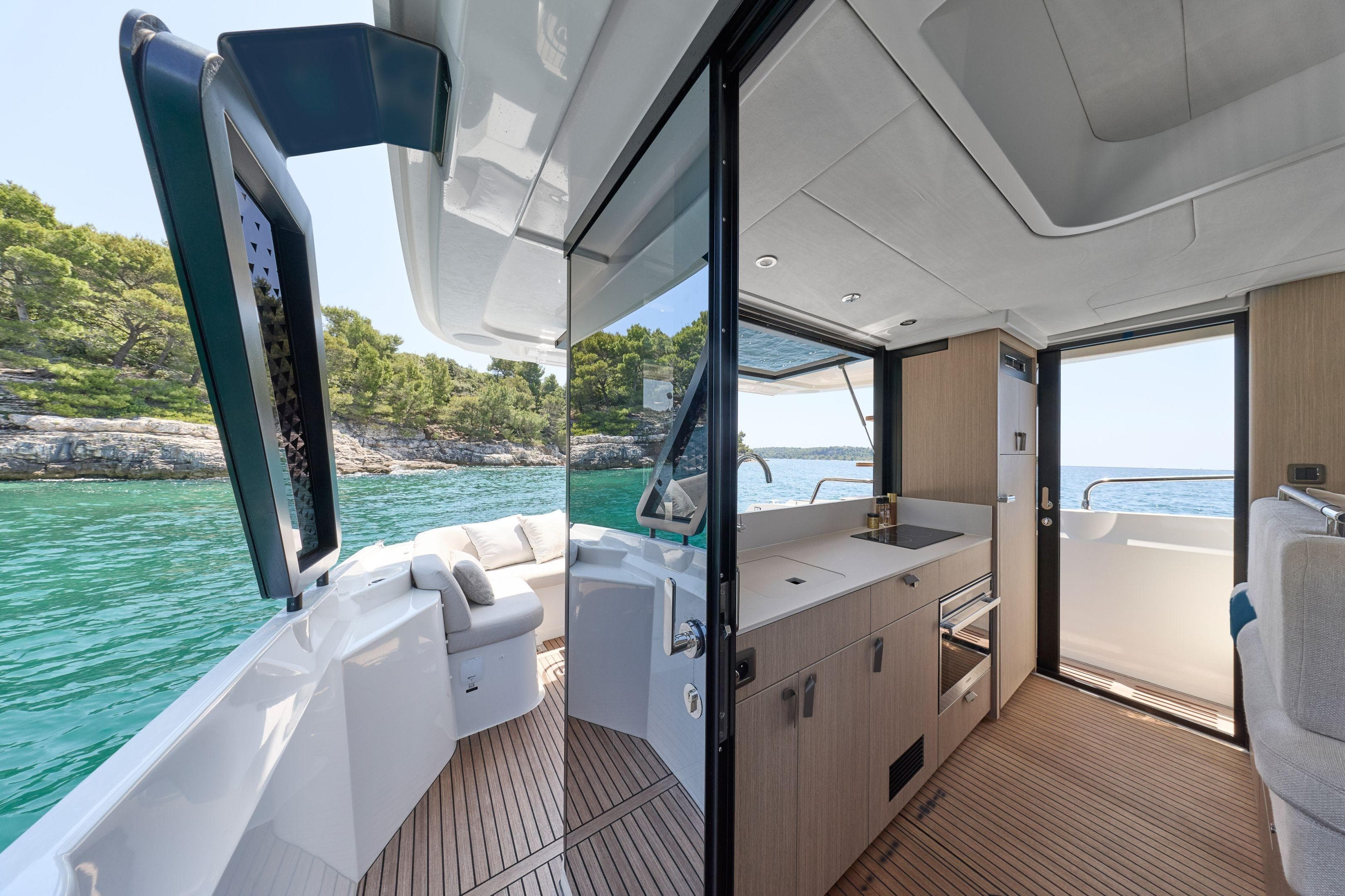 Luxurious Prestige F4.3 yacht interior with modern kitchen, overlooking serene turquoise waters, 2026 model.