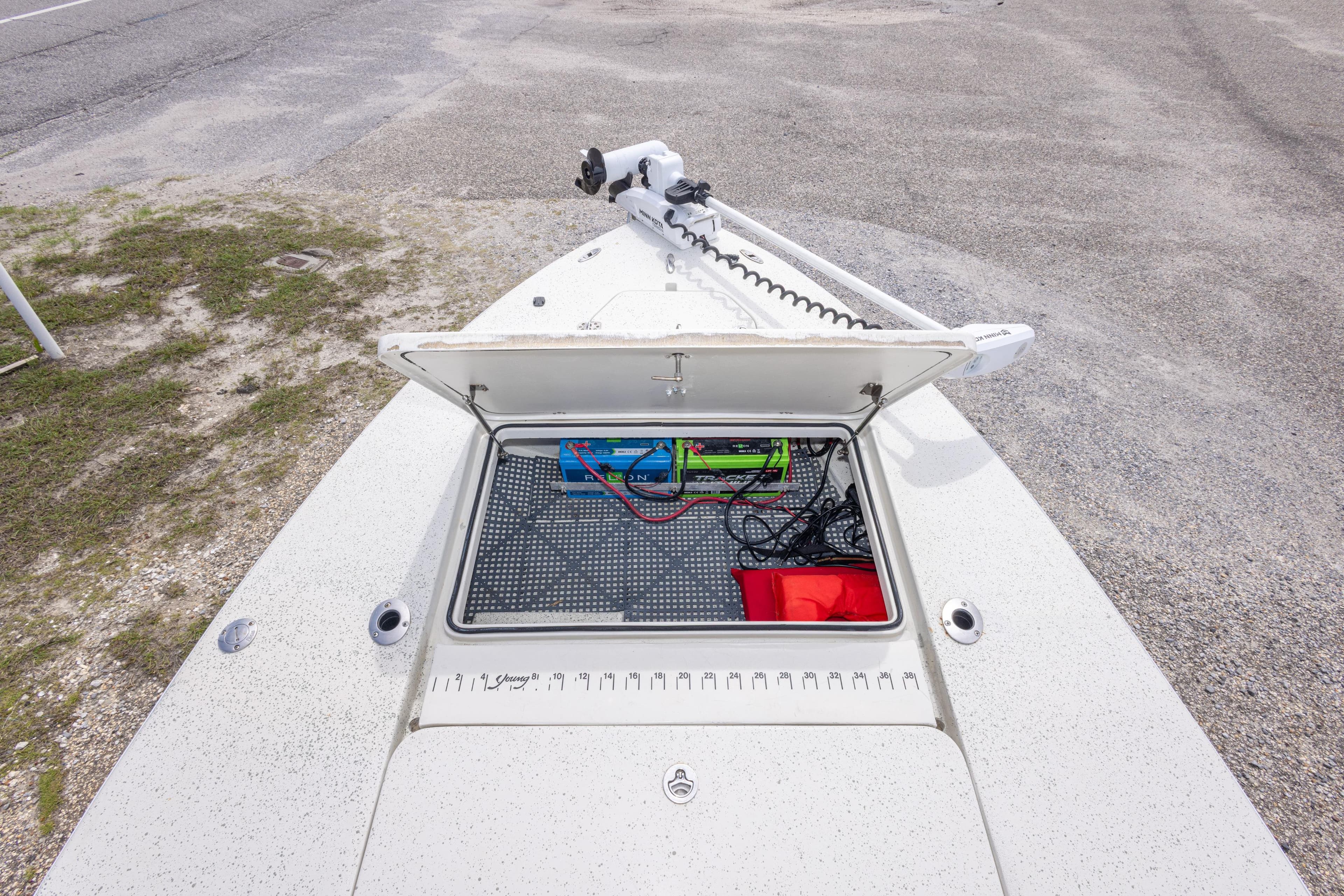 Open storage compartment on 2012 Young GulfShore 20 boat, showing battery and wiring.