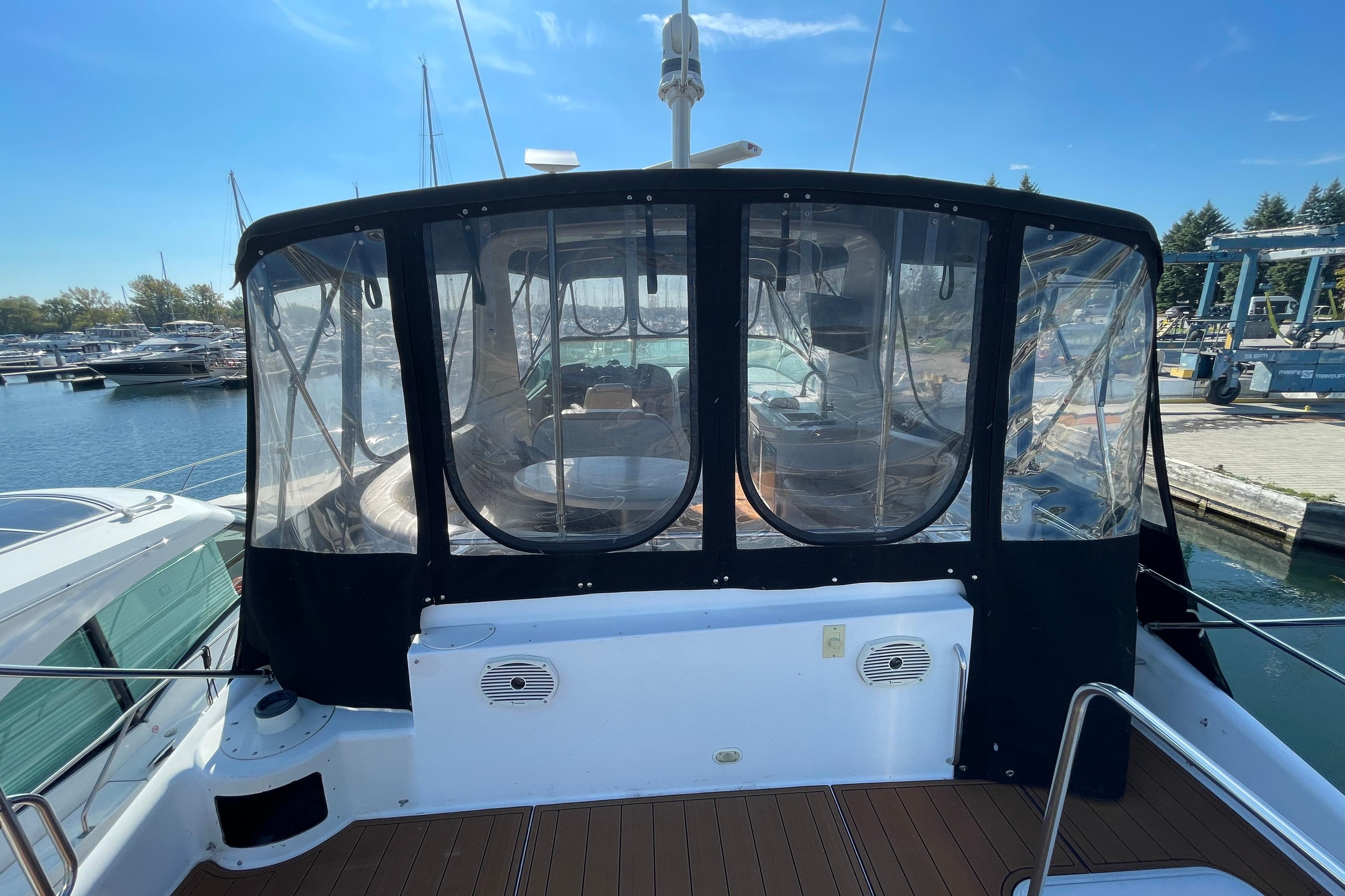 2002 Carver 570 Voyager Pilothouse yacht docked at marina, featuring enclosed cockpit.