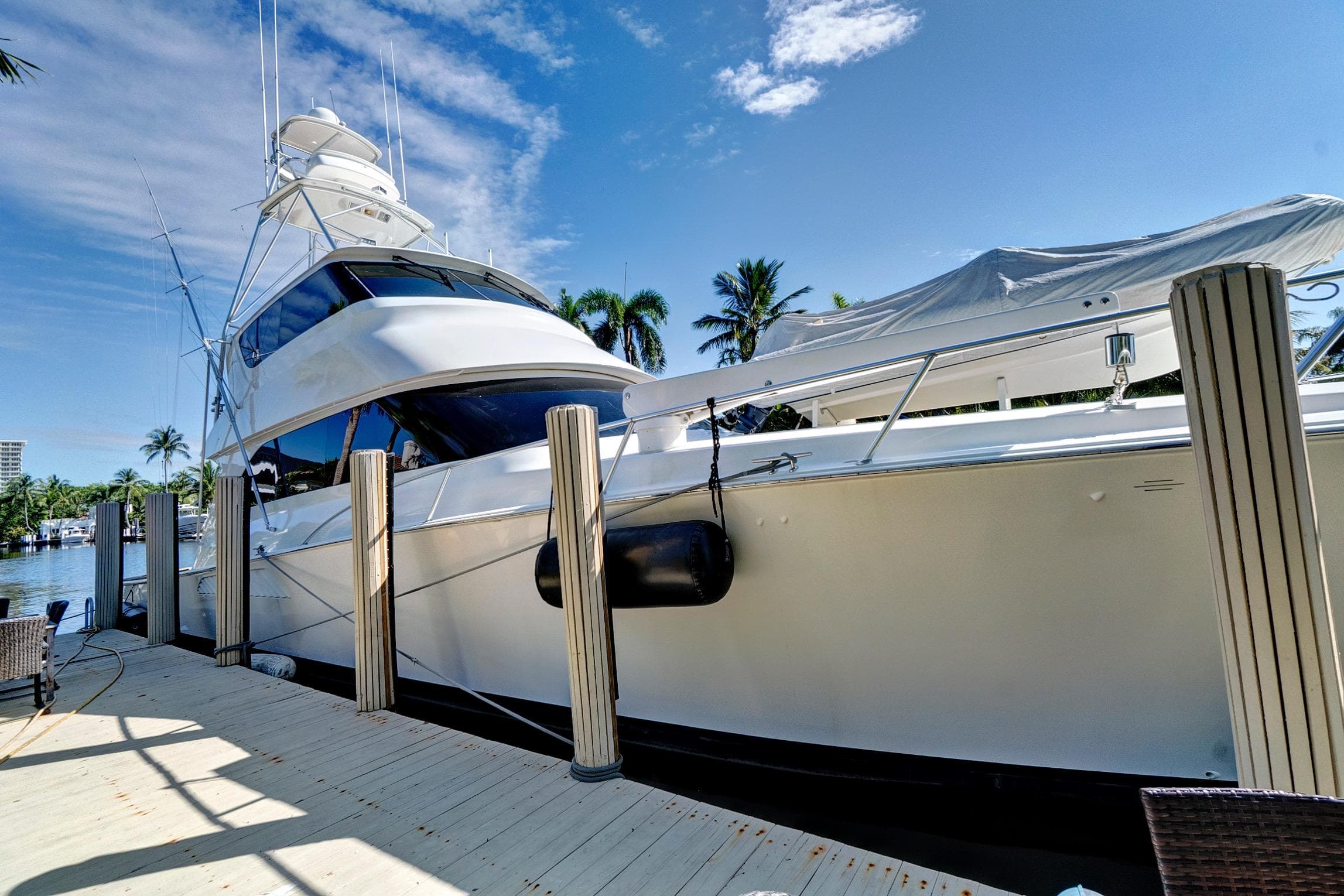 Luxury 2008 Viking 74 Enclosed Bridge yacht docked under clear blue sky.