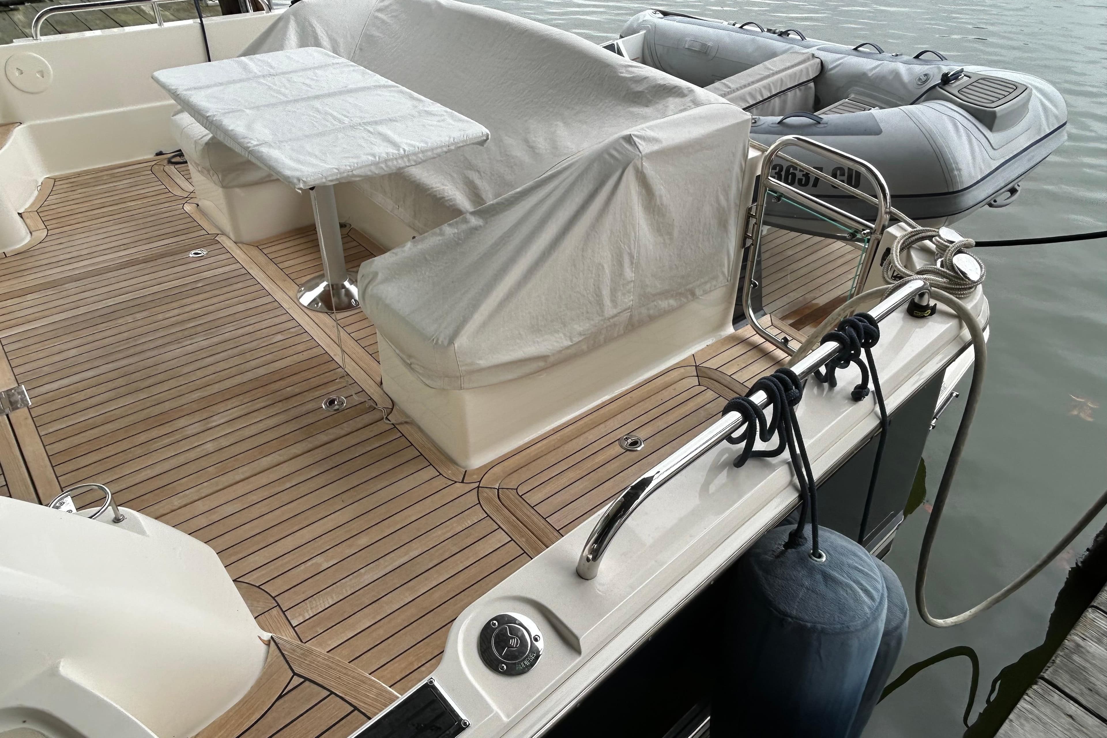 2022 Sabre 45 Salon Express yacht deck with covered seating and inflatable boat.
