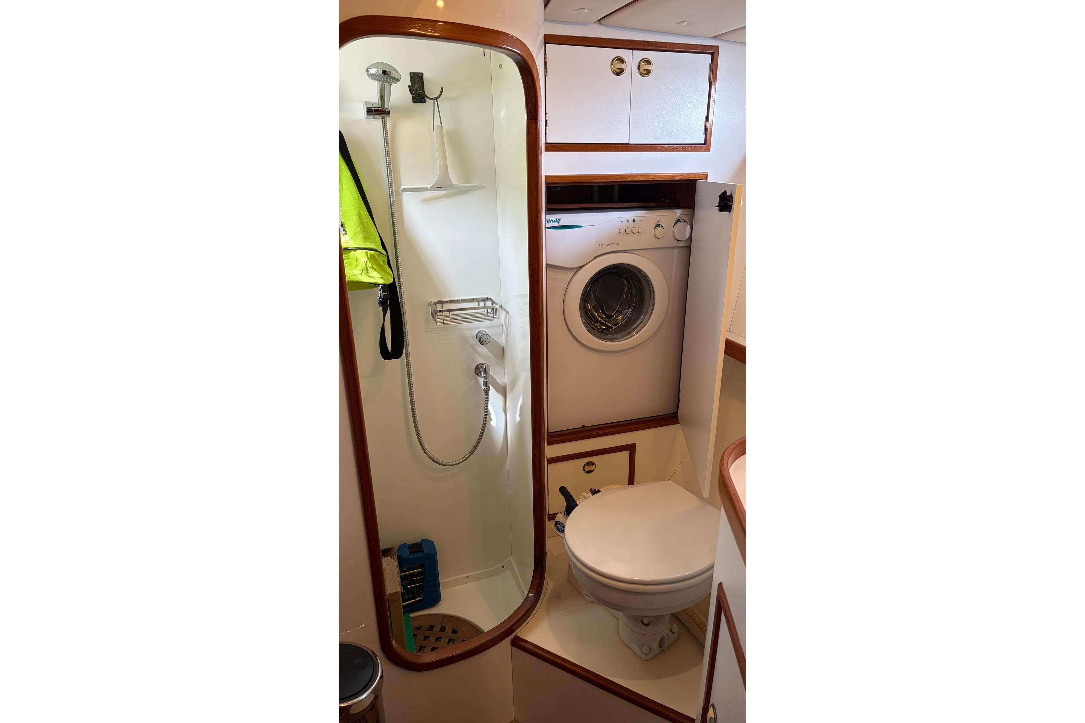 Compact yacht bathroom with shower, toilet, and washing machine in a 1997 Contest 46-48 model.