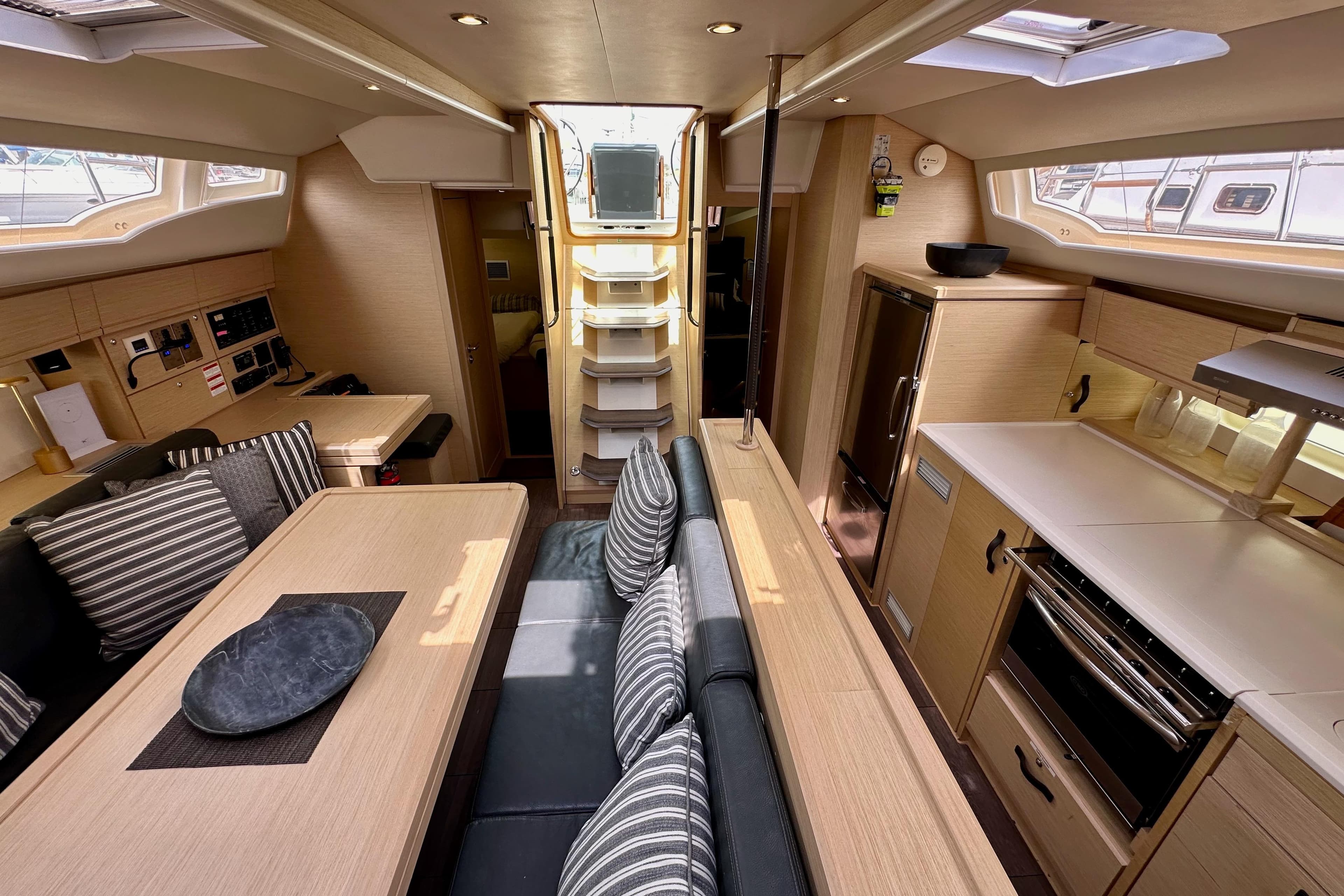 Luxurious interior of 2018 Jeanneau 54 yacht with modern kitchen and dining area.