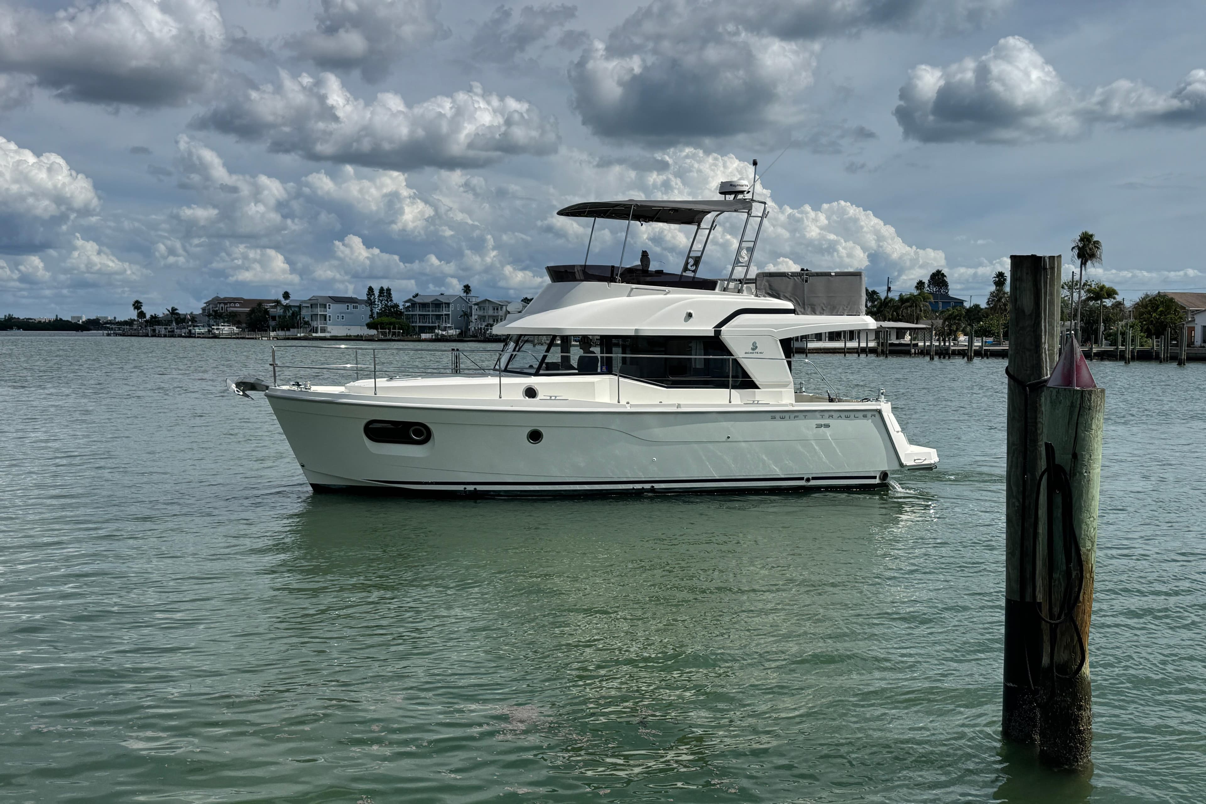 2023 Beneteau Swift Trawler 35 on calm water under cloudy sky.