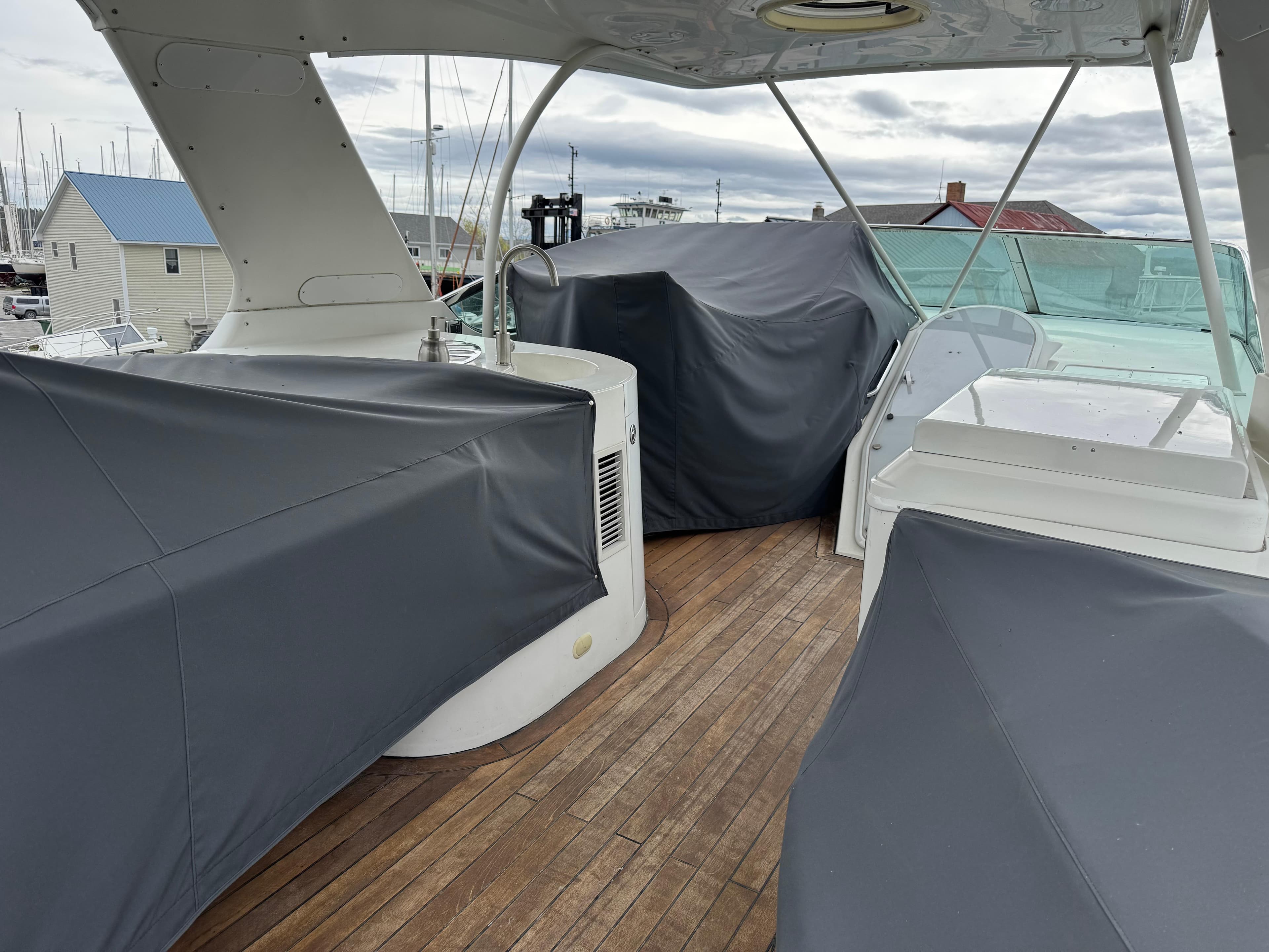 2005 Carver 560 Voyager yacht deck with covered seating and wooden flooring.