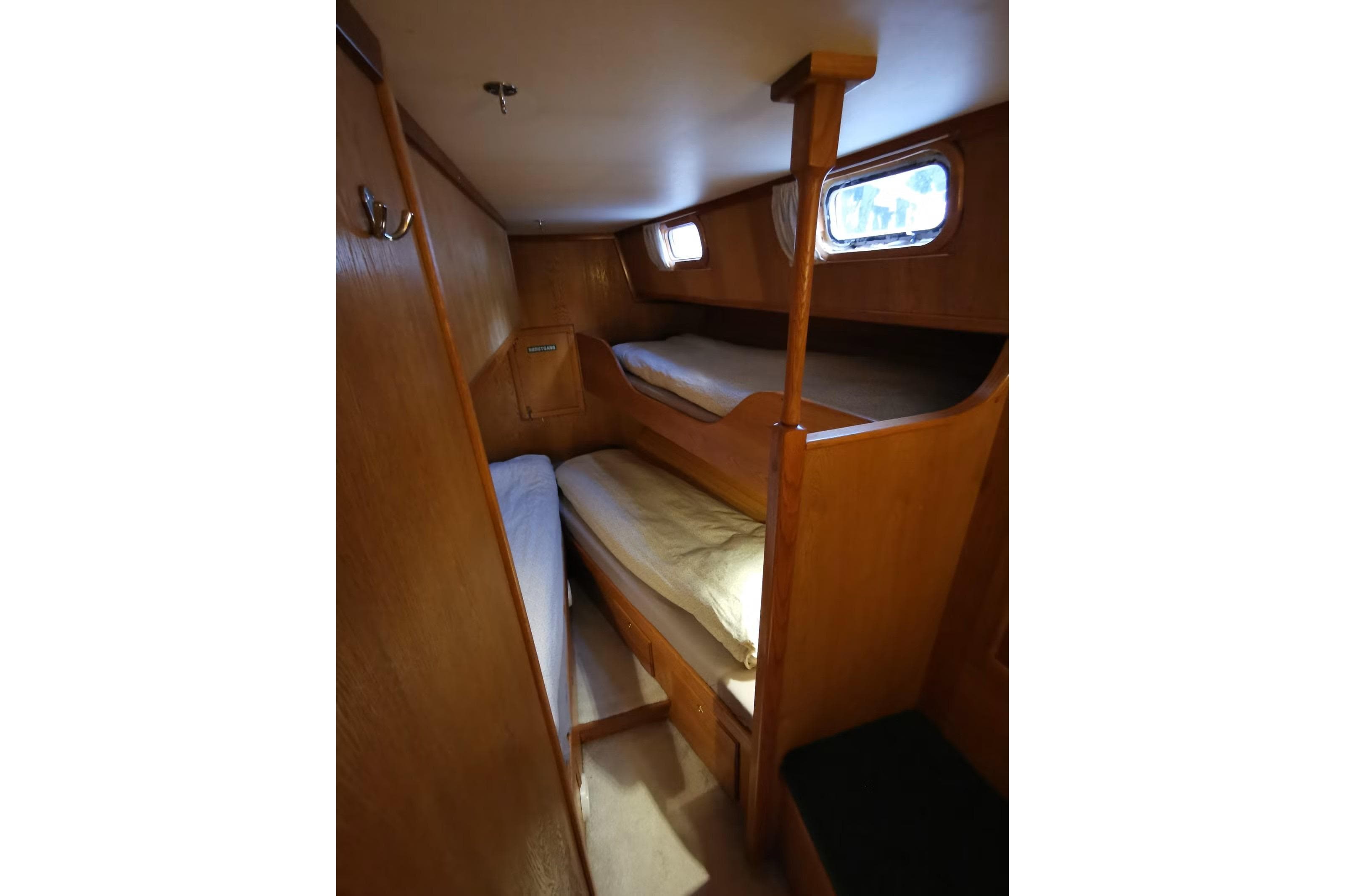 Interior of 1990 Kempers 49 yacht with wooden bunk beds and porthole windows.